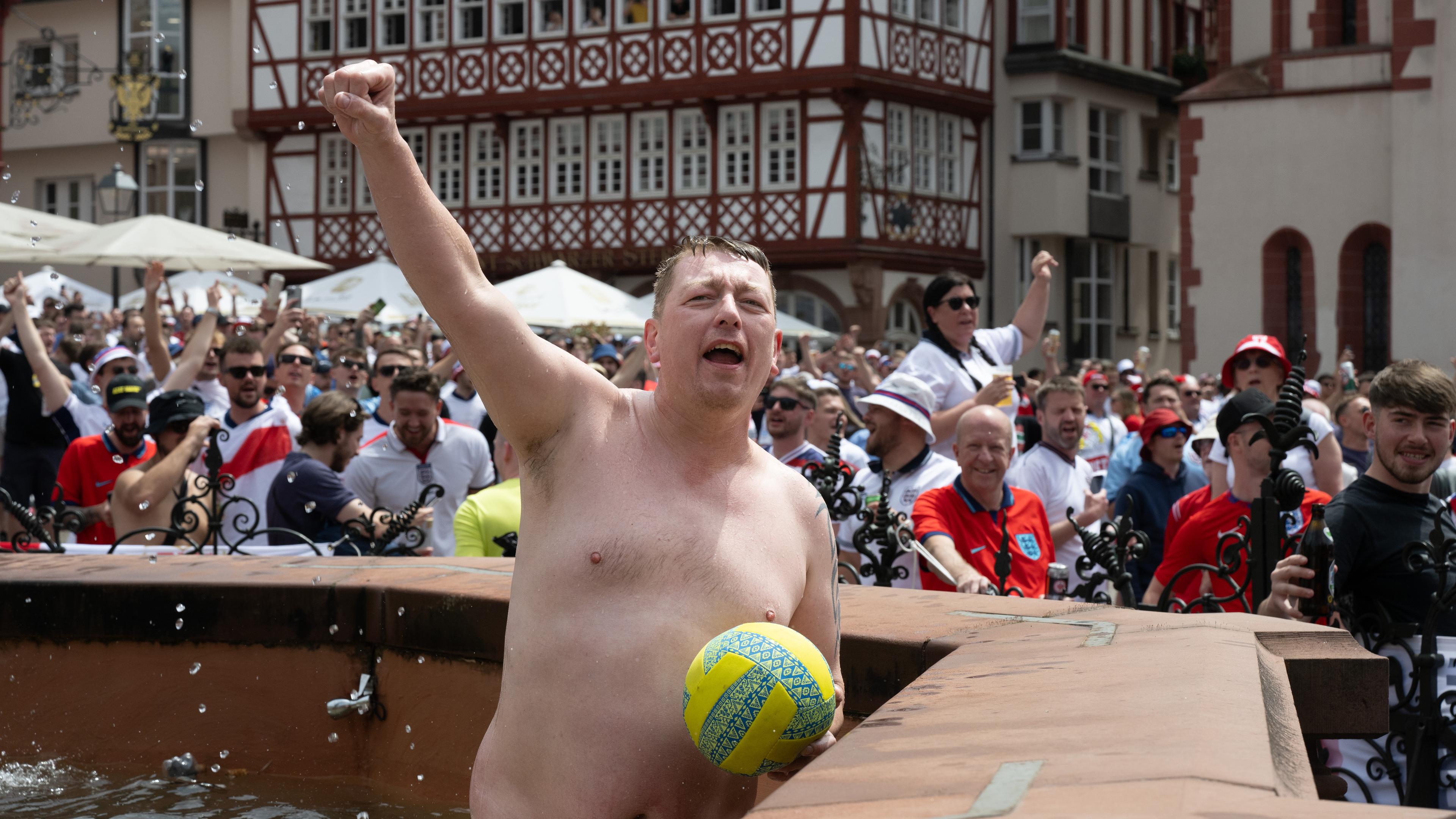 Englische Fans feiern auf dem Römerberg. Dabei ist ein Mann halb nackt in den Justitia-Brunnen gestiegen.