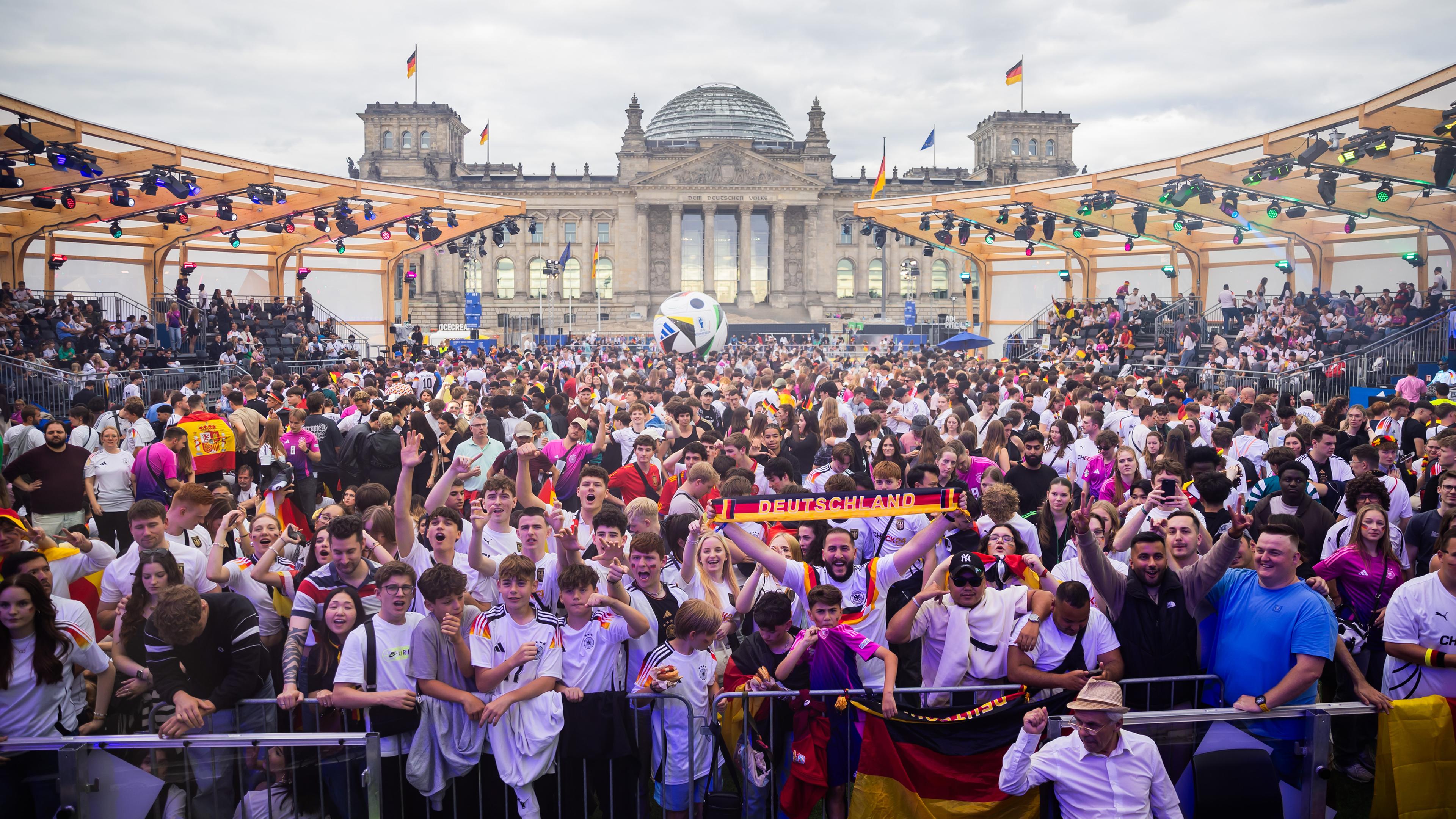 Eine große Menge Menschen mit Fahnen beim Public Viewing in Berlin zum Spiel Deutschland gegen Spanien bei der EM 2024.