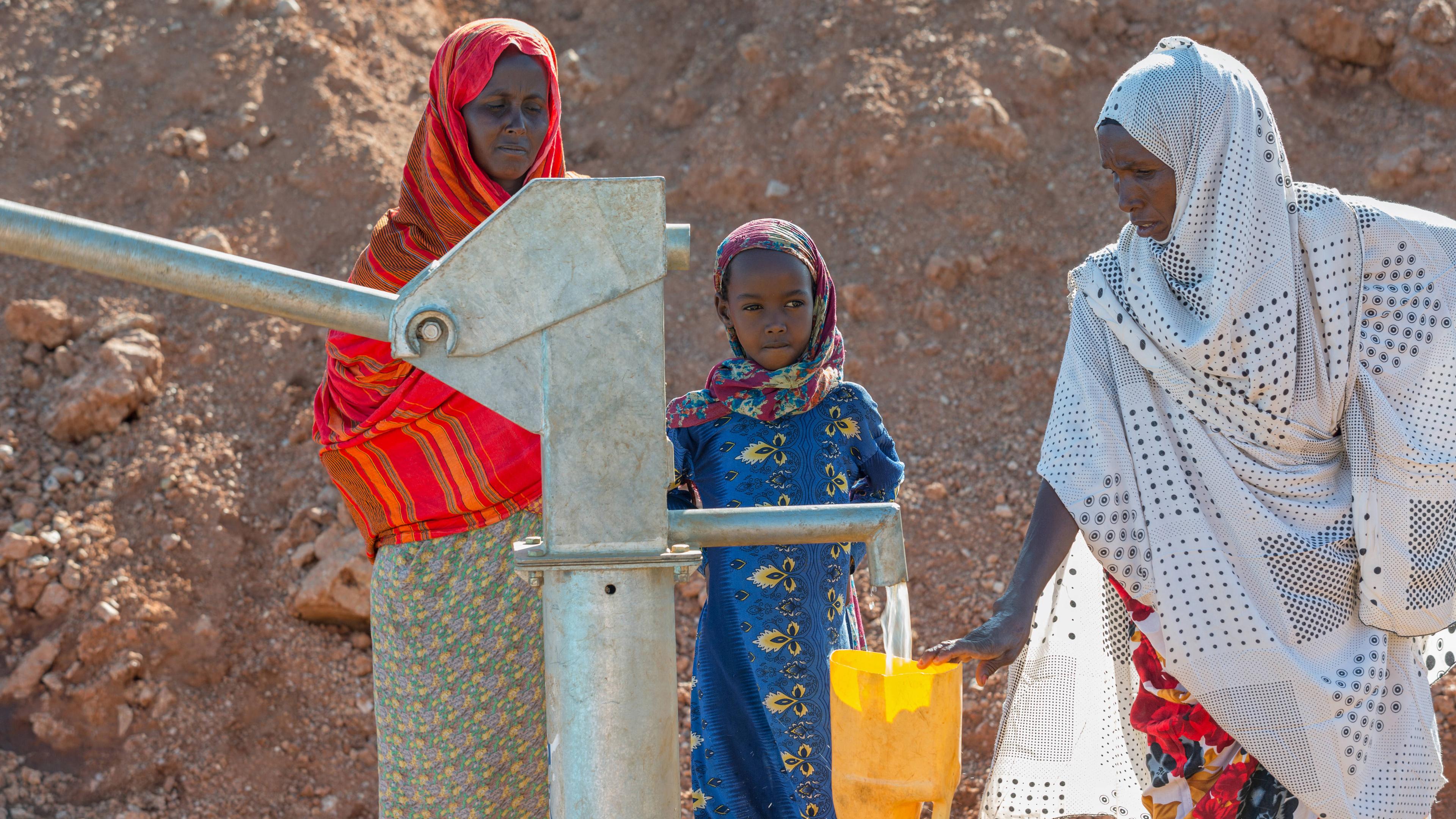Frauen befüllen gelbe Wasserkanister an einer Wasserpumpe in Gabradahidan (Somali Region, Äthiopien)