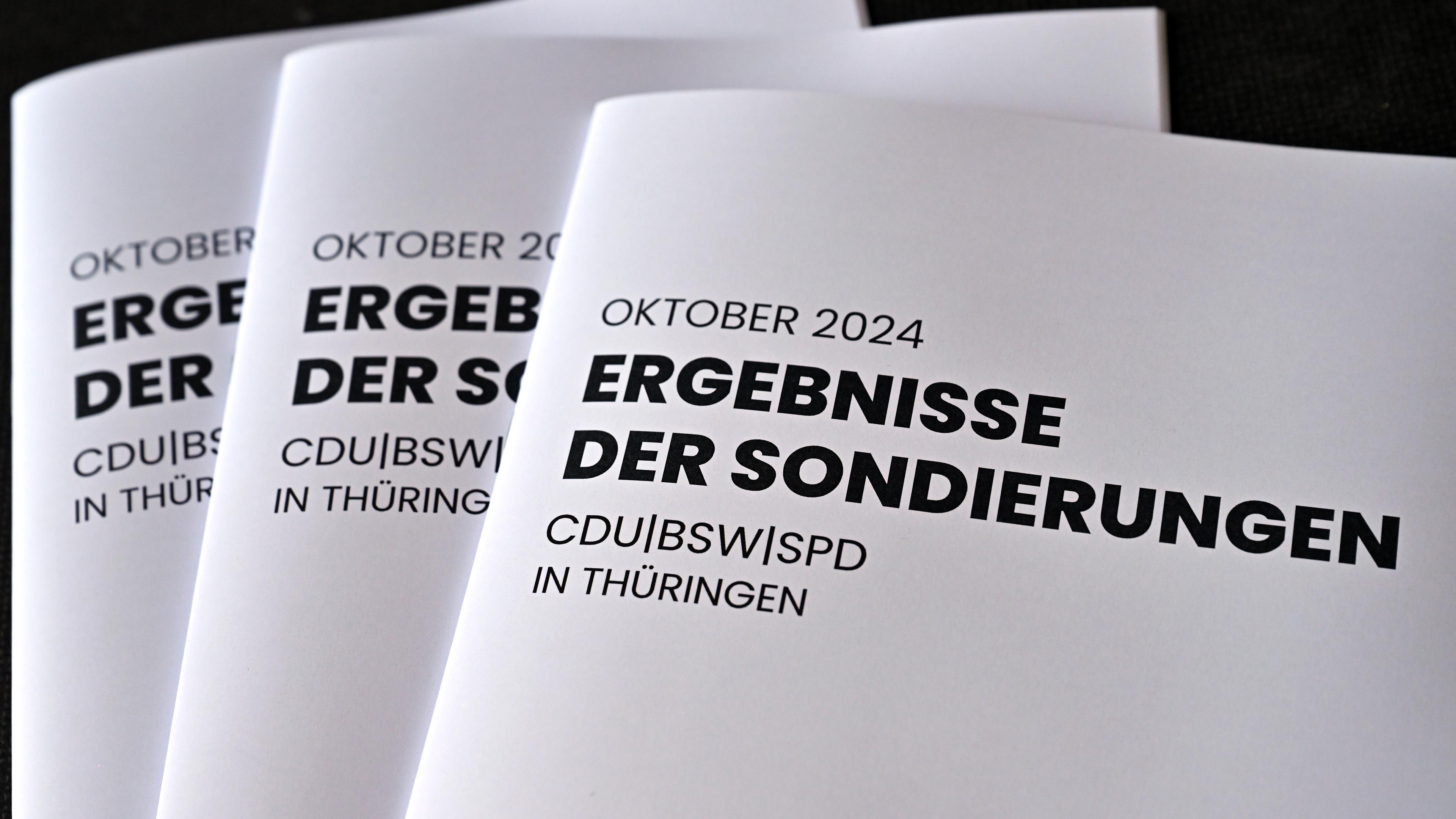 18.10.2024, Thüringen, Erfurt: Eine Druckschrift mit dem Titel ·Ergebnisse der Sondierungen· werden während einer Pressekonferenz zu den Ergebnissen der Sondierungsgespräche zwischen CDU, BSW und SPD in der Erfurter Zentralheize präsentiert.