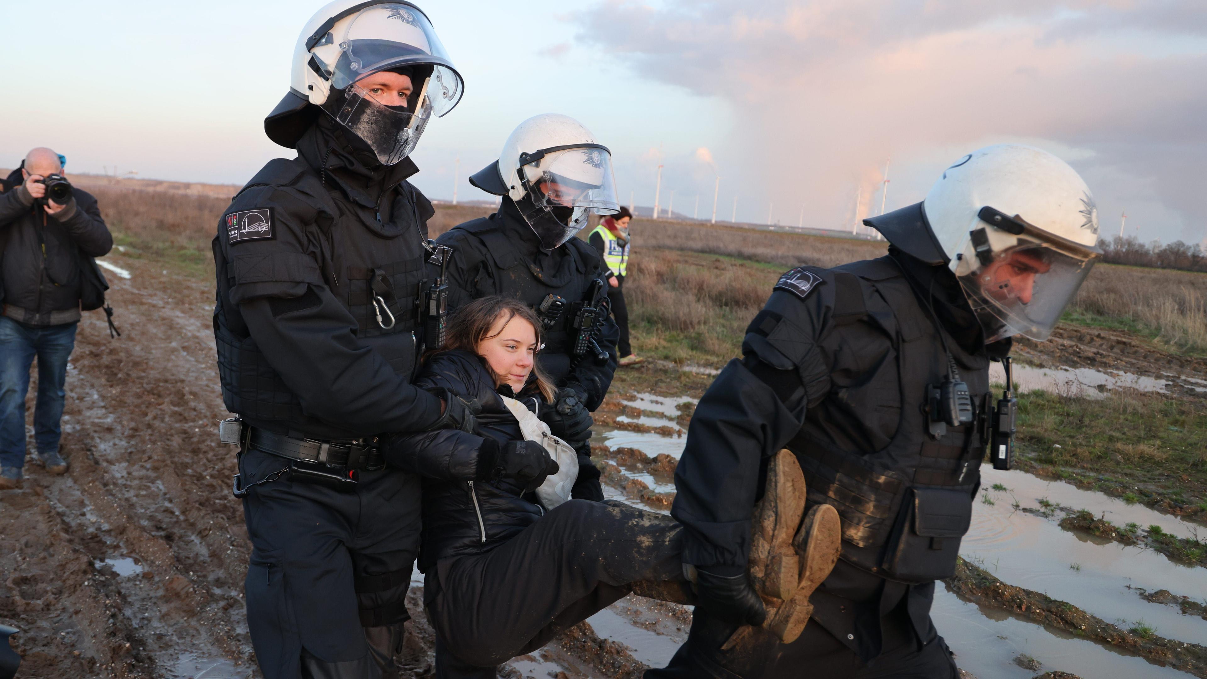Nordrhein-Westfalen, Erkelenz: Polizisten tragen die schwedische Klimaaktivistin Greta Thunberg (M) aus einer Gruppe von Demonstranten und Aktivisten heraus und vom Rand des Braunkohlentagebaus Garzweiler II weg.