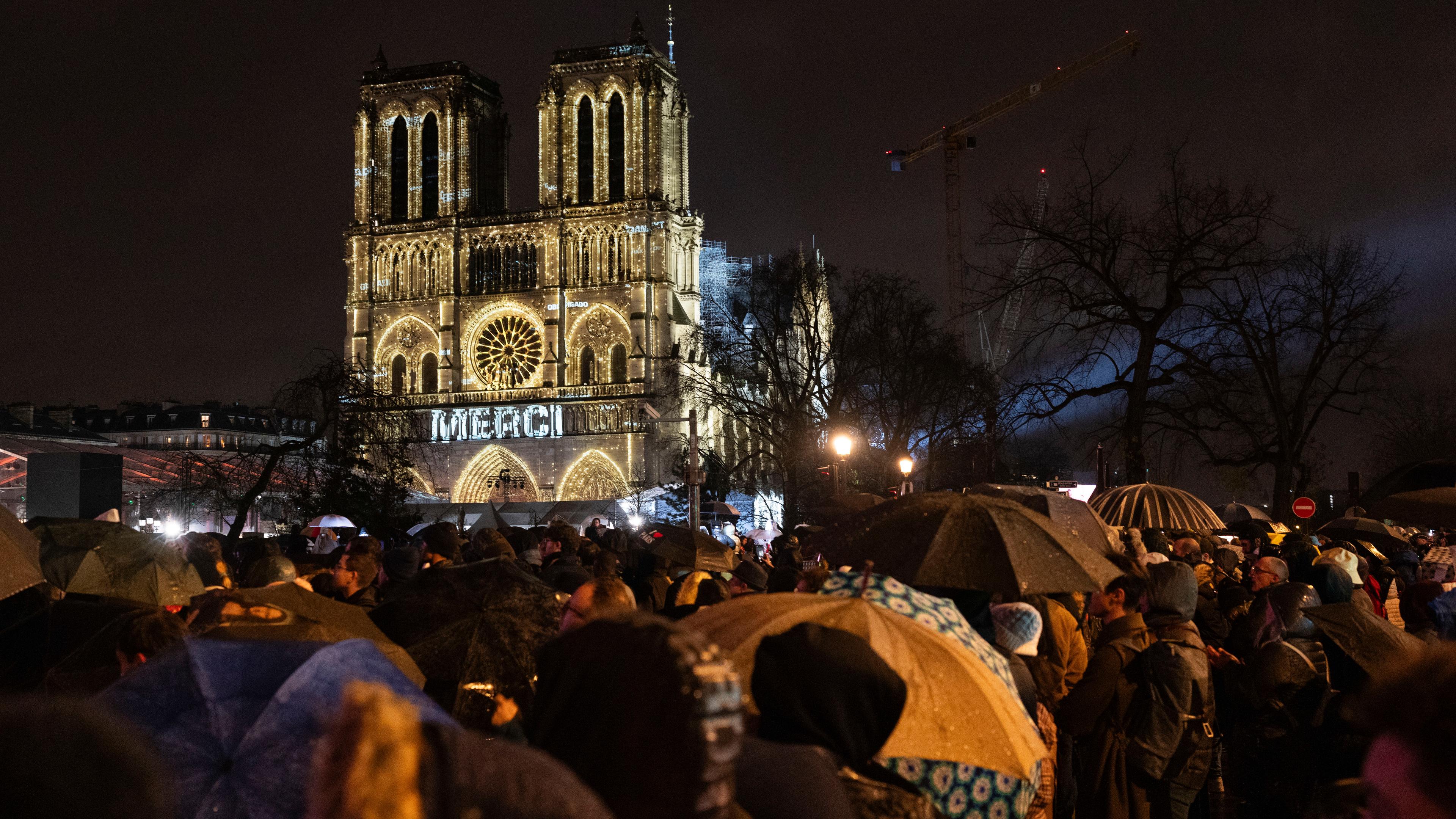 Zuschauer versammeln sich vor der Kathedrale Notre Dame in Paris, die zum ersten Mal seit einem verheerenden Brand, der das 861 Jahre alte Wahrzeichen 2019 fast zerstört hätte, offiziell wiedereröffnet wird. 