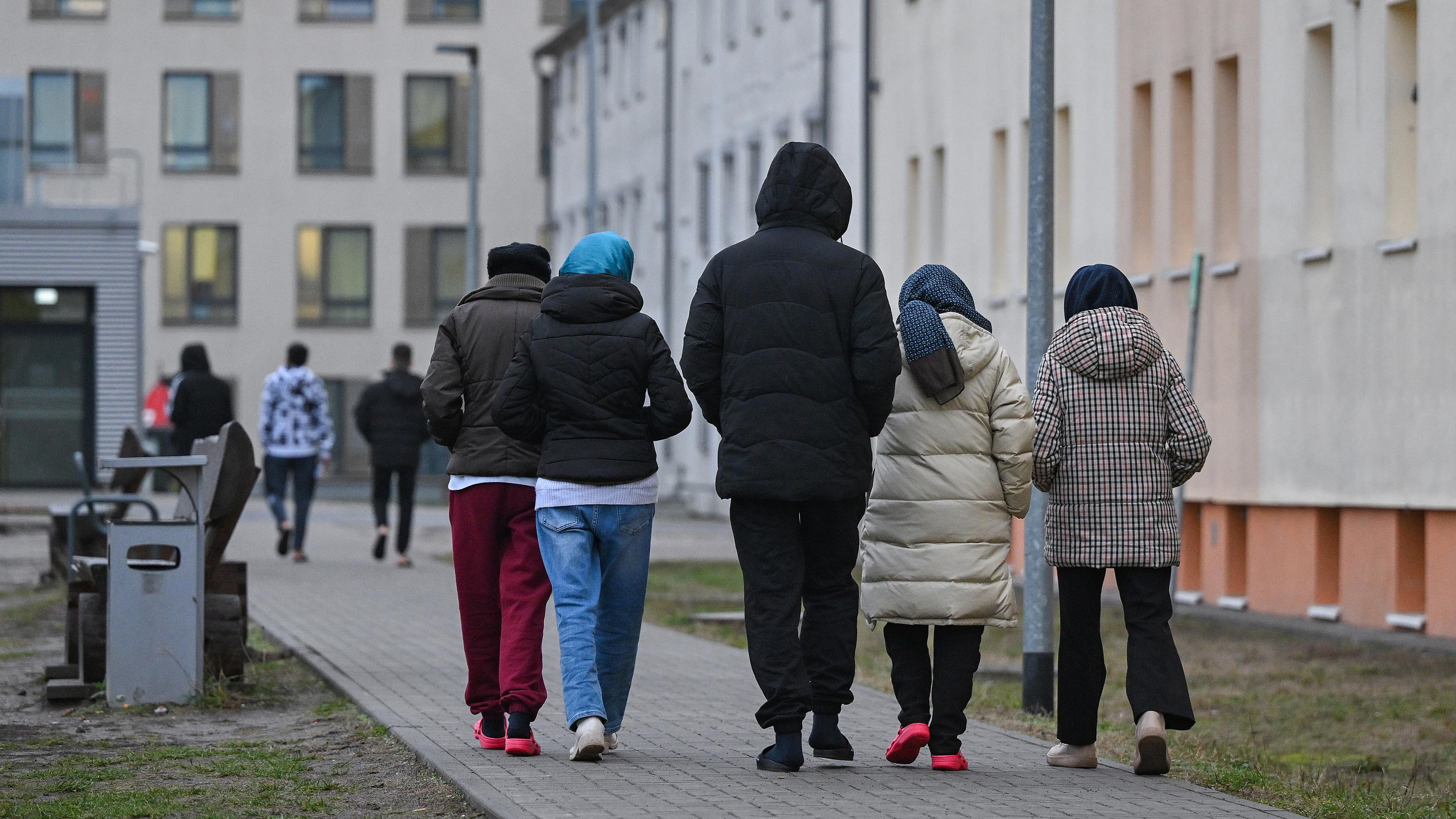 Migranten gehen über das Gelände der Zentralen Erstaufnahmeeinrichtung für Asylbewerber (ZABH) des Landes Brandenburg in Eisenhüttenstadt