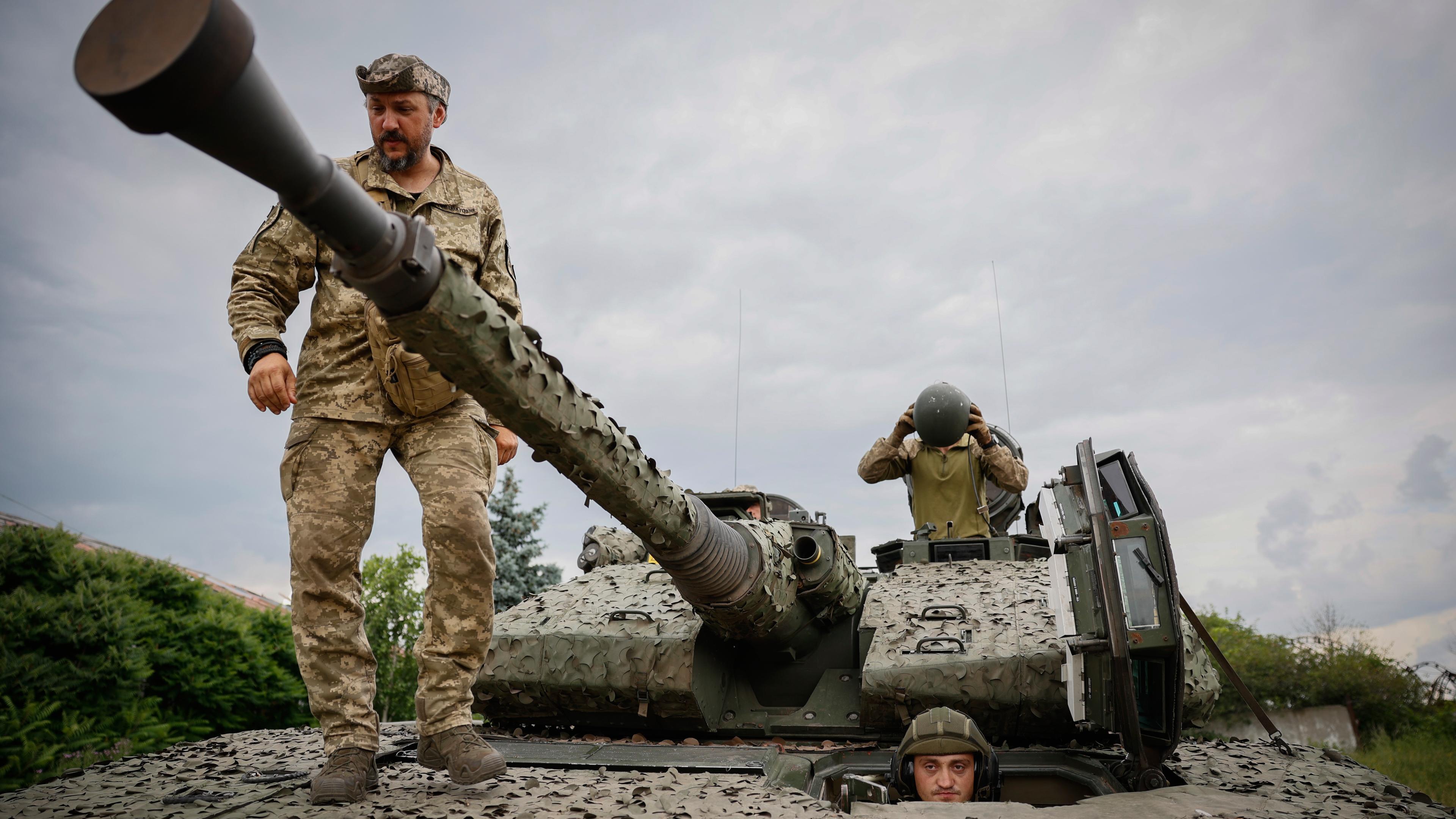 Das Bild zeigt ukrainische Soldaten, die auf einem schwedischen CV90-Schützenpanzer stehen.