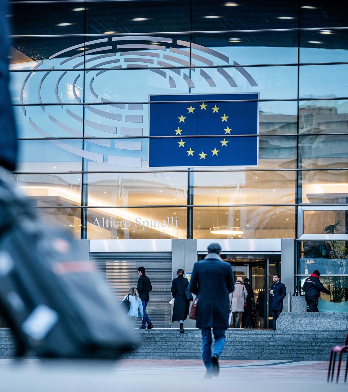 Passanten gehen vor dem Sitz des europäischen Parlaments in Brüssel entlang. 