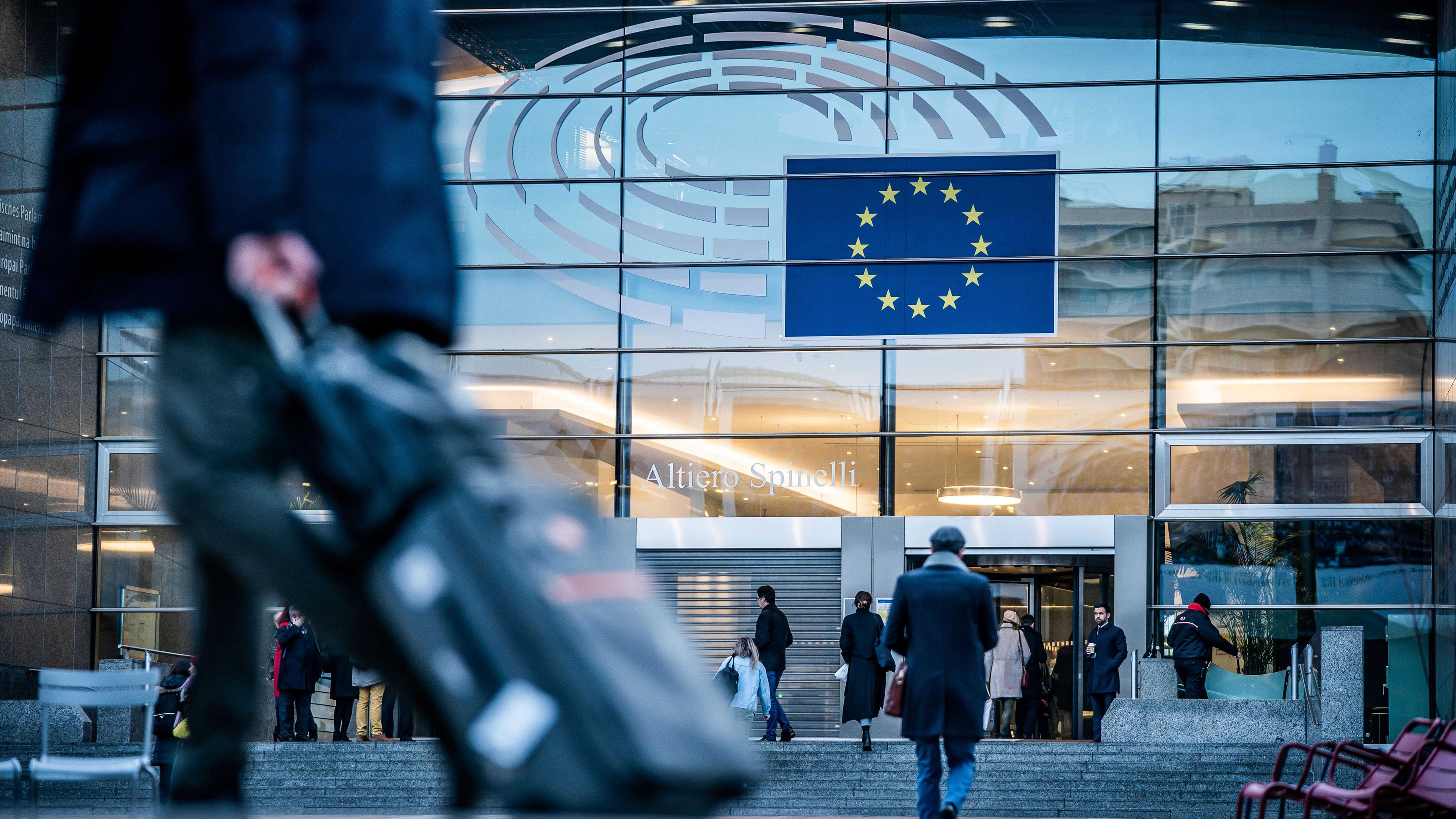 Passanten gehen vor dem Sitz des europäischen Parlaments in Brüssel entlang. 