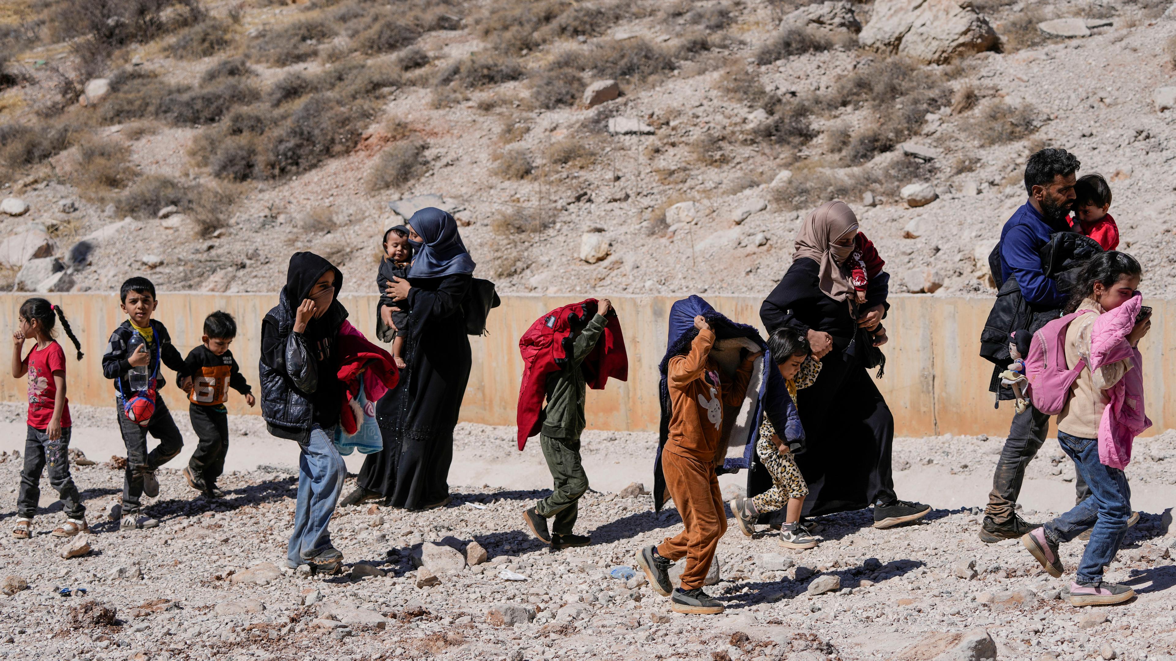  Familien aus dem Libanon überqueren zu Fuß die Grenze nach Syrien durch einen Krater.