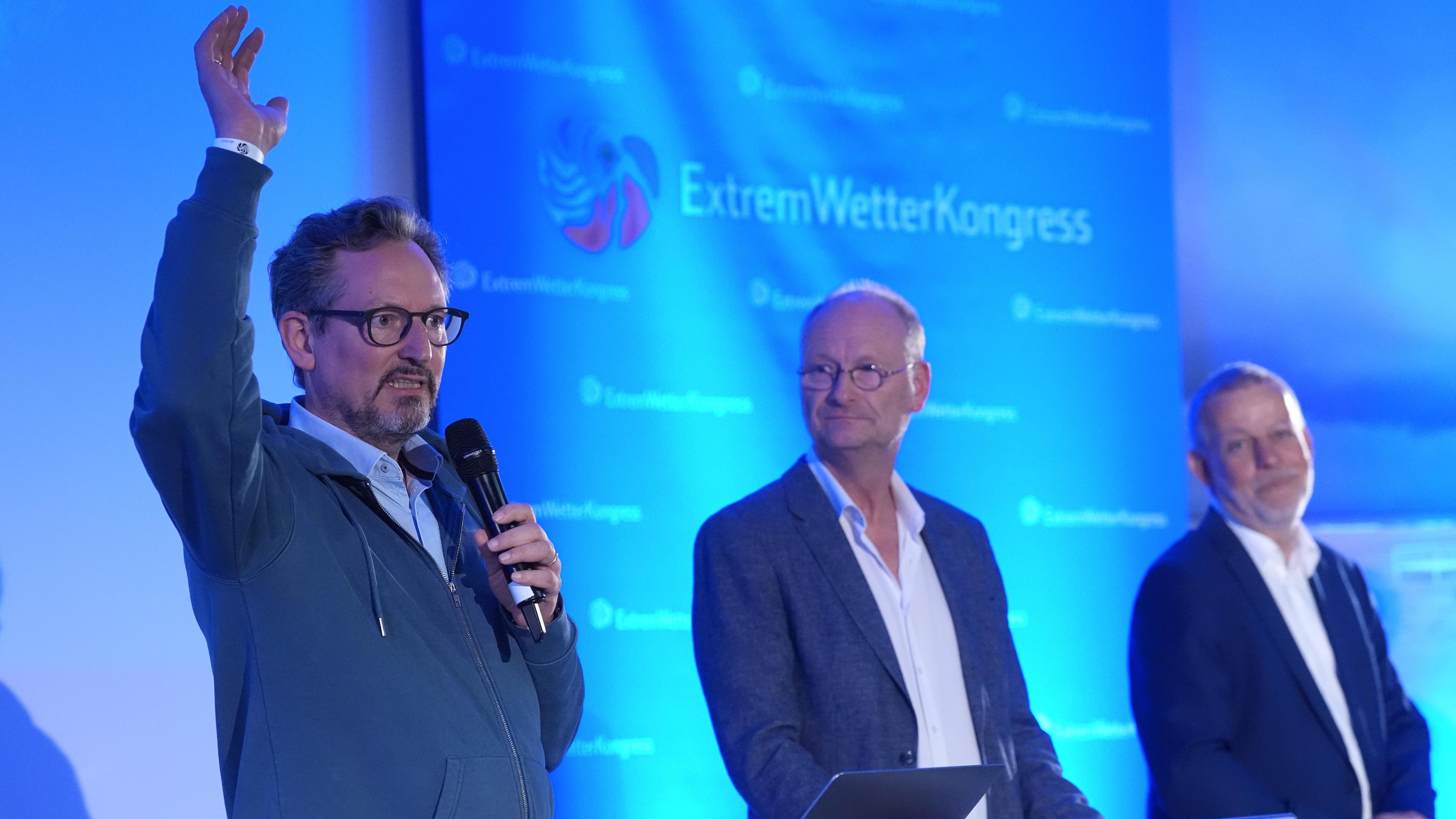 Eckart von Hirschhausen (l-r), Stiftung Gesunde Erde - Gesunde Menschen gGmbH (GEGM) sowie Mediziner, Autor und TV-Moderator, spricht neben Sven Plöger, Meteorologe und Buchautor, und Tobias Fuchs, Vorstand Klima und Umwelt beim Deutschen Wetterdienst (DWD)