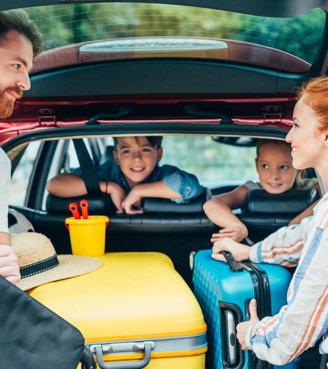 Familie beim Beladen des Kofferraums ihres Autos