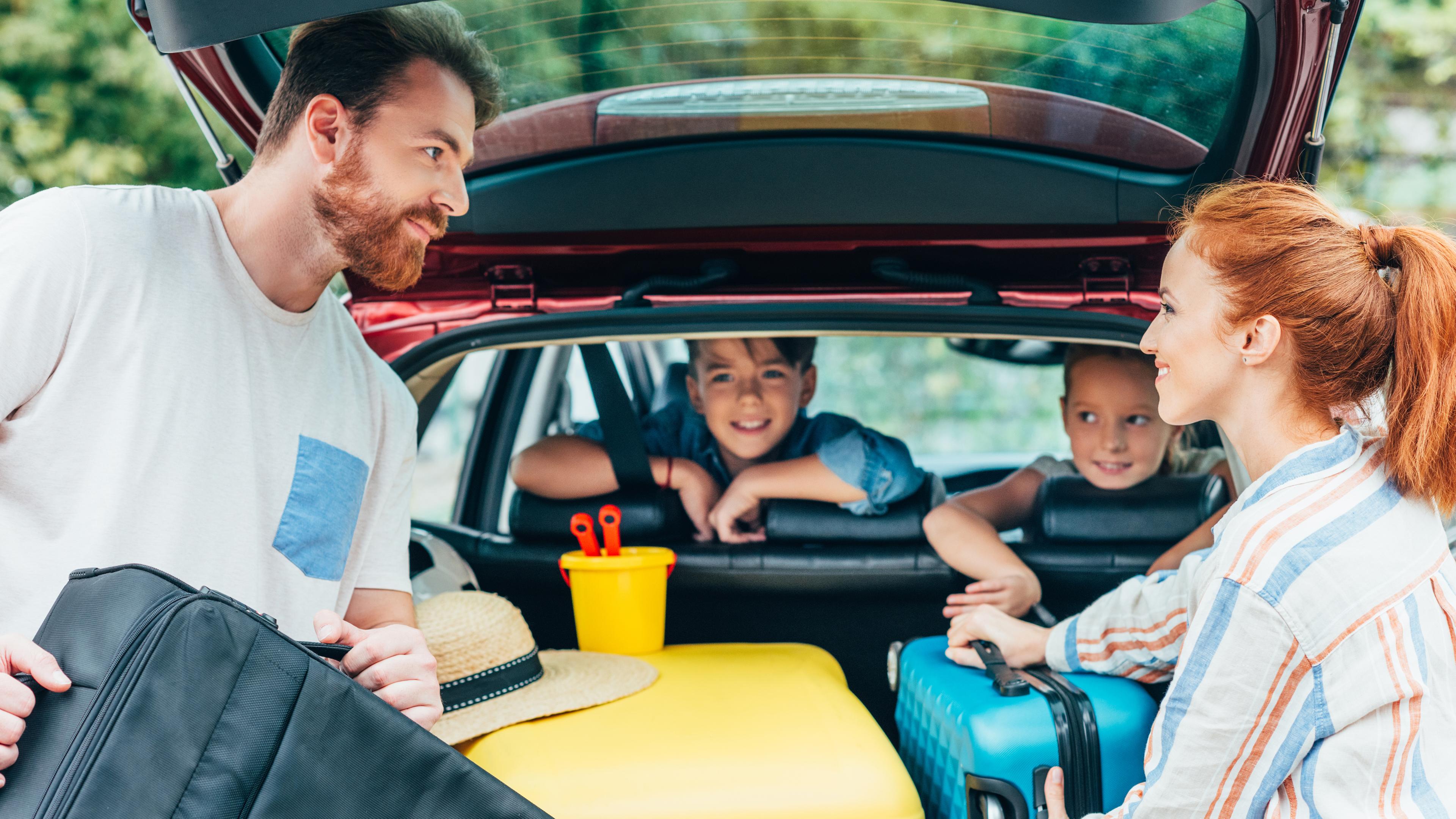 Familie beim Beladen des Kofferraums ihres Autos