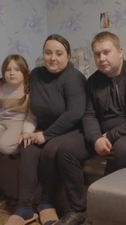 Eine Familie sitzt auf einer Couch im ukrainischen Charkiw.