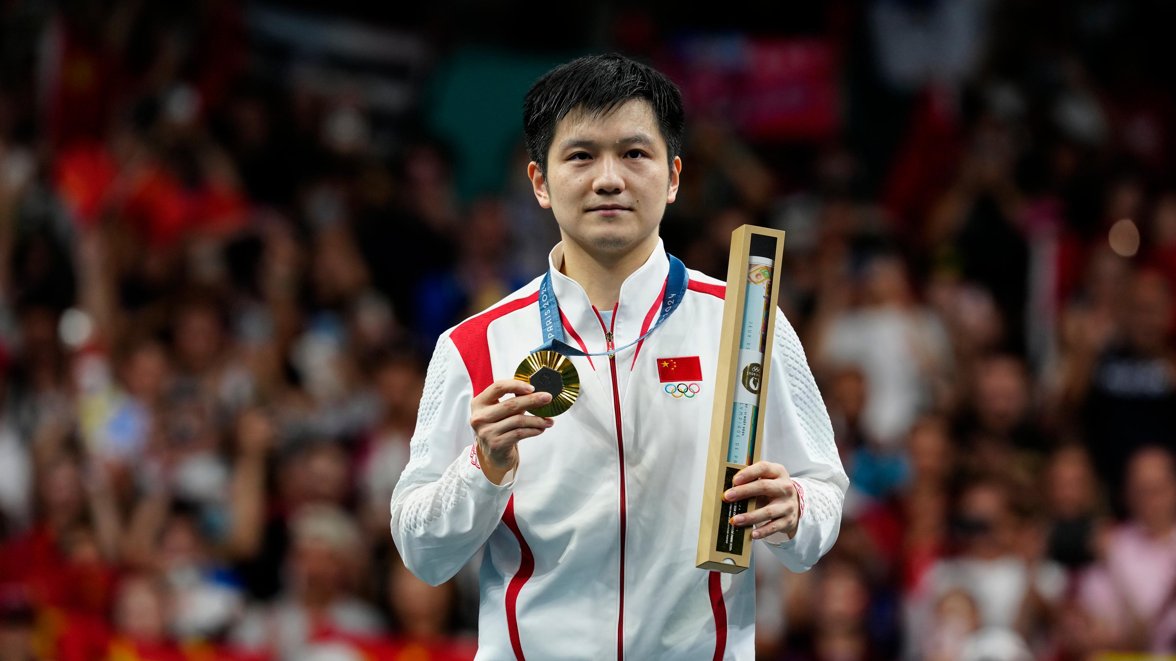 Goldmedaillengewinner Fan Zhendong posiert während der Medaillenzeremonie.