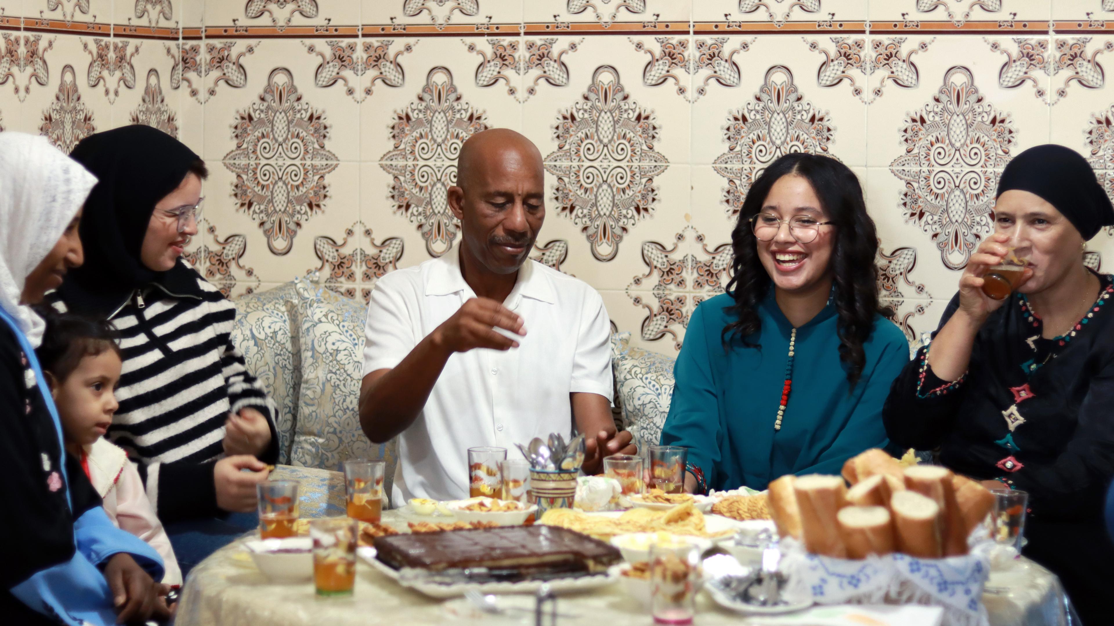 Farah Mouknnaa sitzt mit ihrer Familie am Esstisch in Marokko
