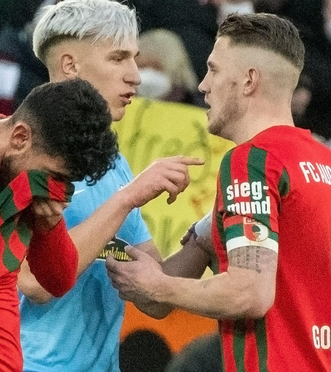 19.02.2022, Bayern, Augsburg: Fußball: Bundesliga, FC Augsburg - SC Freiburg, 23. Spieltag in der WWK-Arena. Augsburgs Ricardo Pepi (l) und Jeffrey Gouweleeuw (r) mit Freiburgs Nico Schlotterbeck.