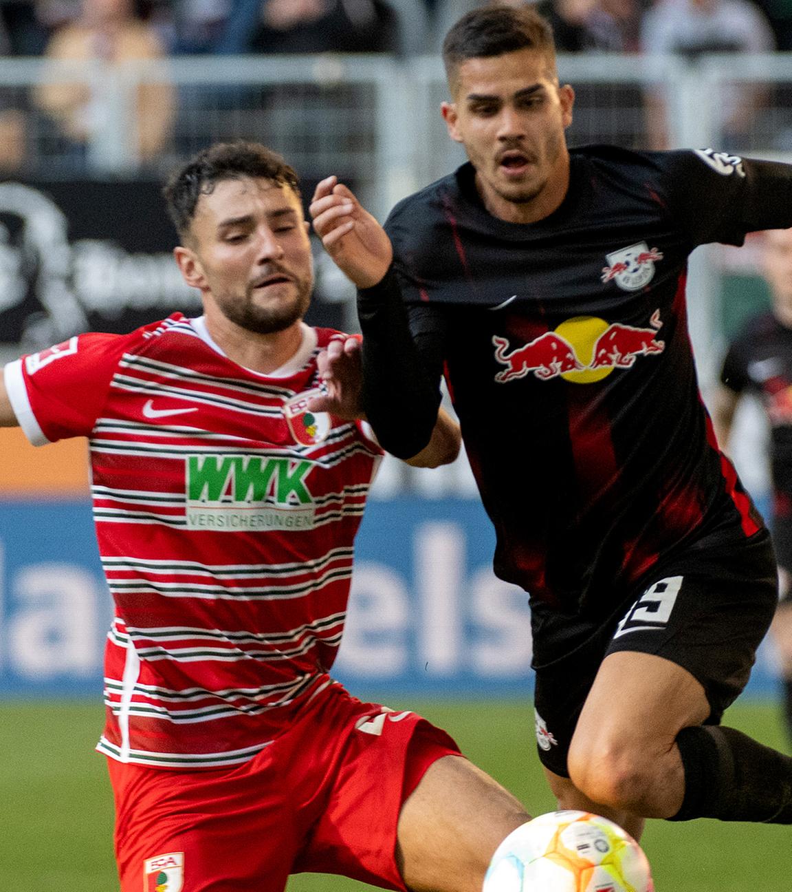 Augsburgs Maximilian Bauer (l) und Leipzigs Andre Silva kämpfen um den Ball am 22.10.2022 in Augsburg.