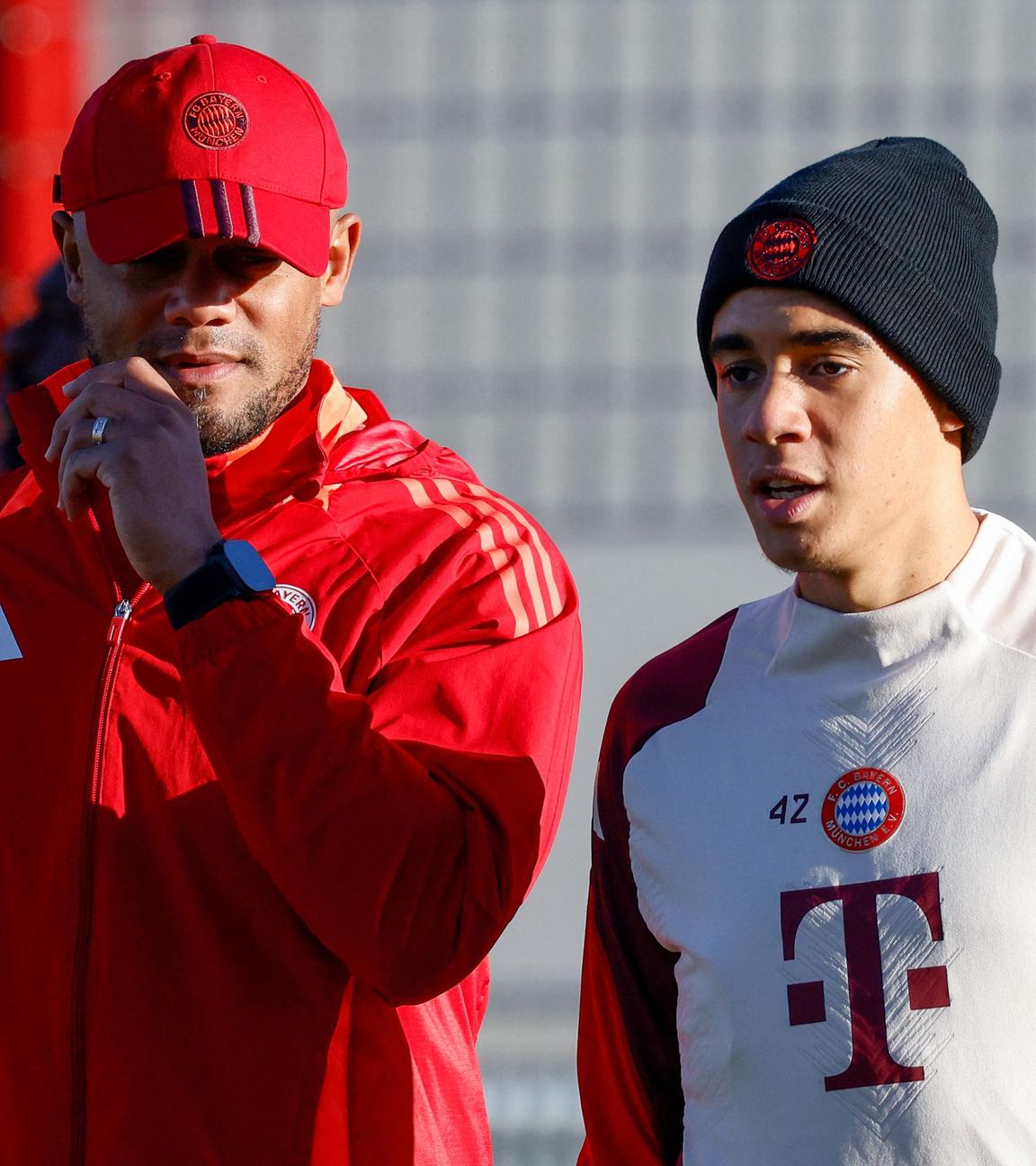 Bayern-Trainer Vincent Kompany spricht im Training mit Jamal Musiala.