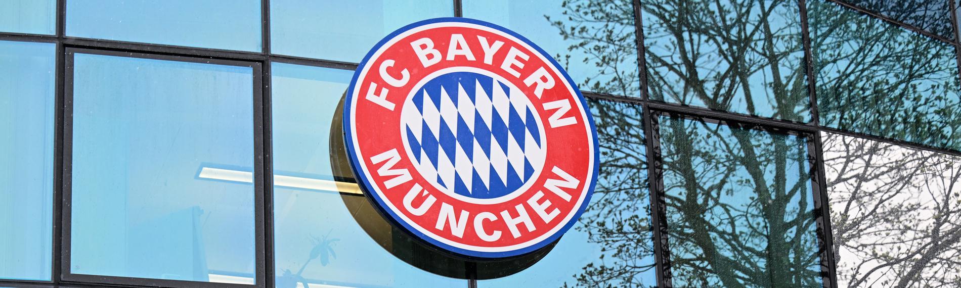 Logo und Schriftzug des FC Bayern München am Vereinsgelände.