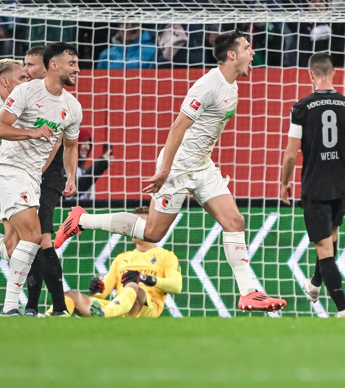 Fußball-Bundesliga, FC Augsburg - Bor. Mönchengladbach: Augsburgs Keven Schlotterbeck (r.) jubelt nach seinem Tor zum 1:0.