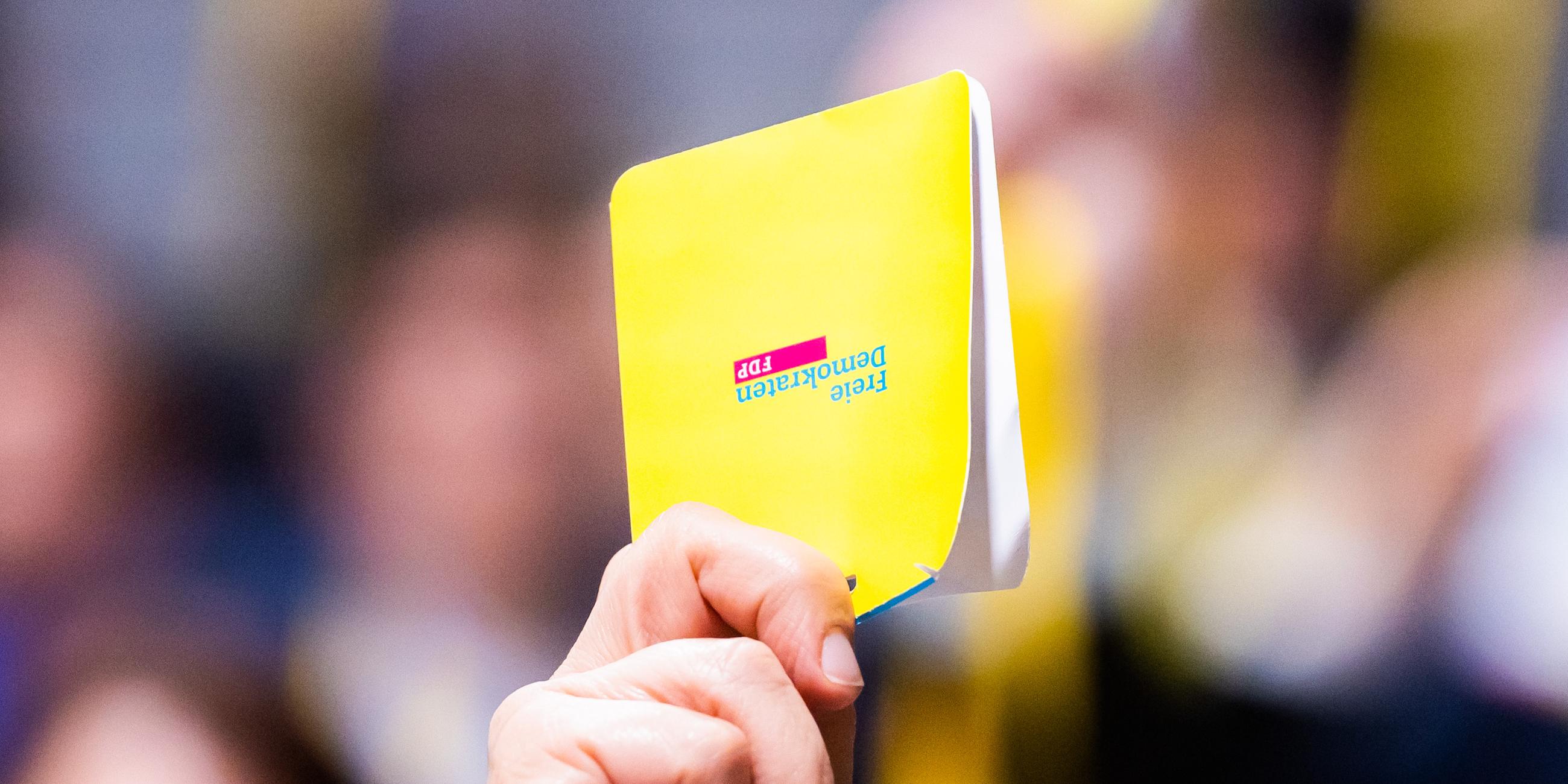 Eine Stimmkarte wird beim FDP-Bundesparteitag in die Höhe gehalten.