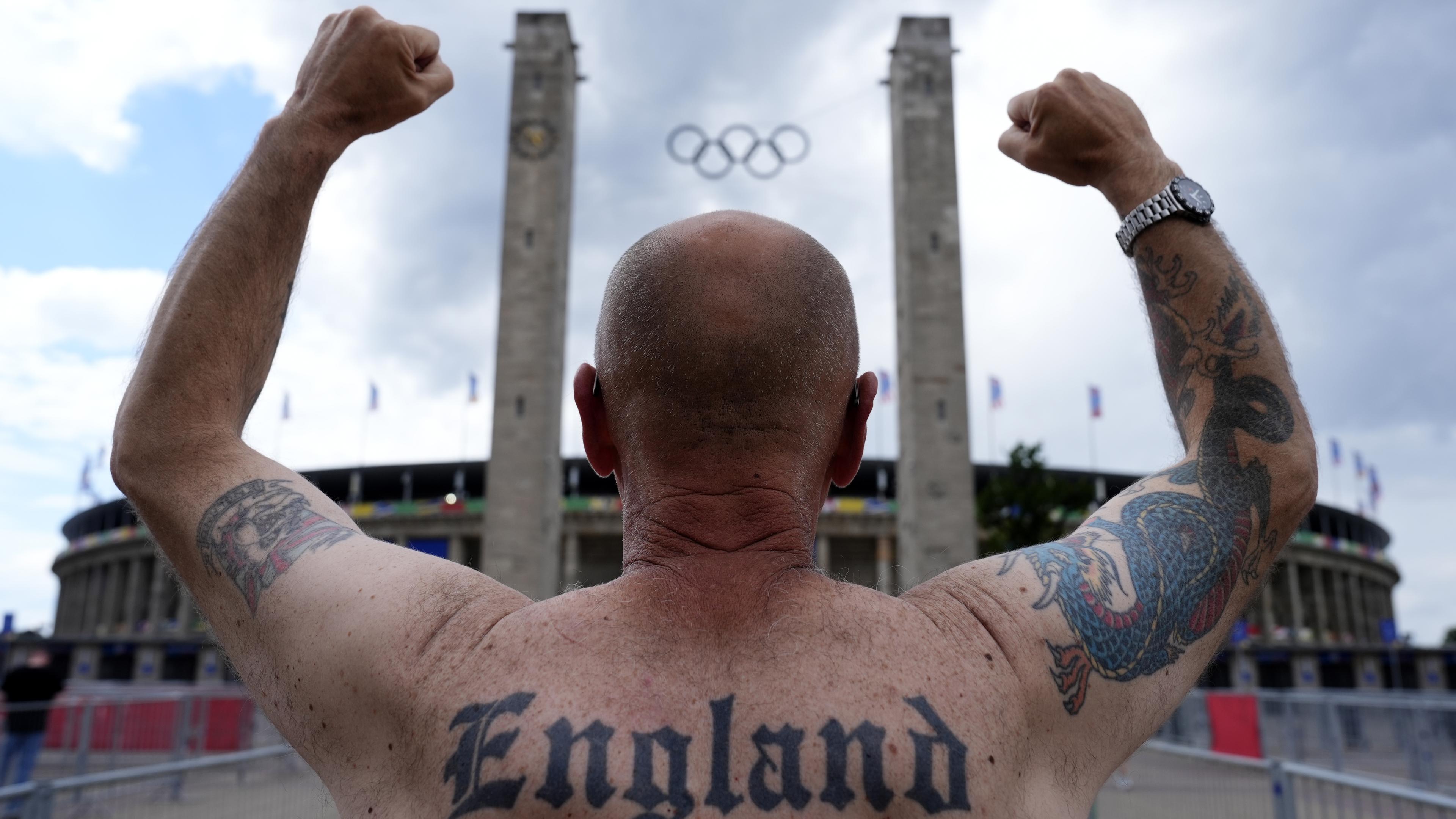 England-Fan Jason Cook gestikuliert vor dem Olympiastadion, auf seinem Rücken sieht man ein "England"-Tattoo.