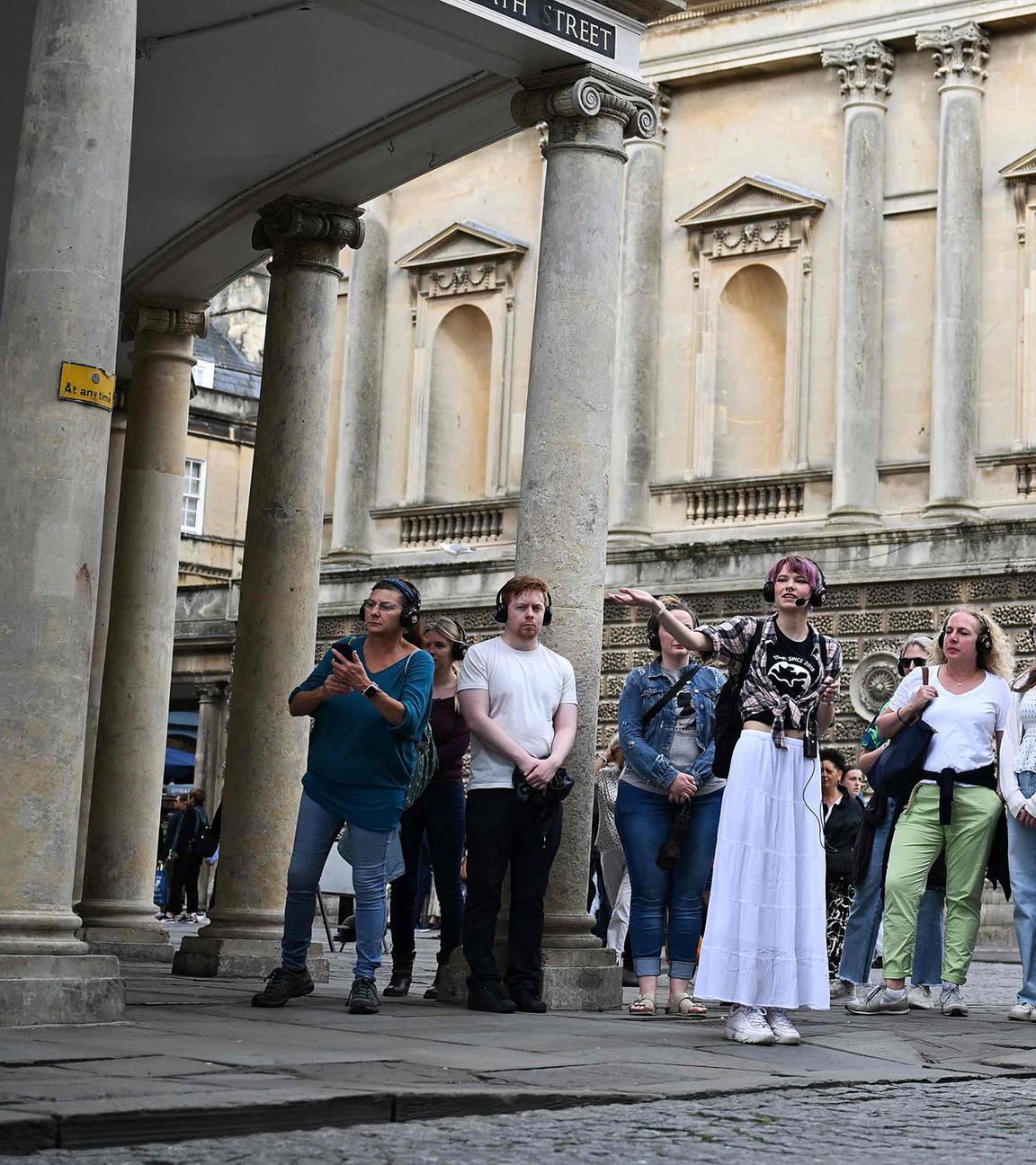 Besucher hören der Reiseleiterin Ruby Maidment zu, während sie am 16. Juli 2024 die Sets der Netflix-Serie "Bridgerton" in Bath, Westengland, entdecken am 16.07.2024 