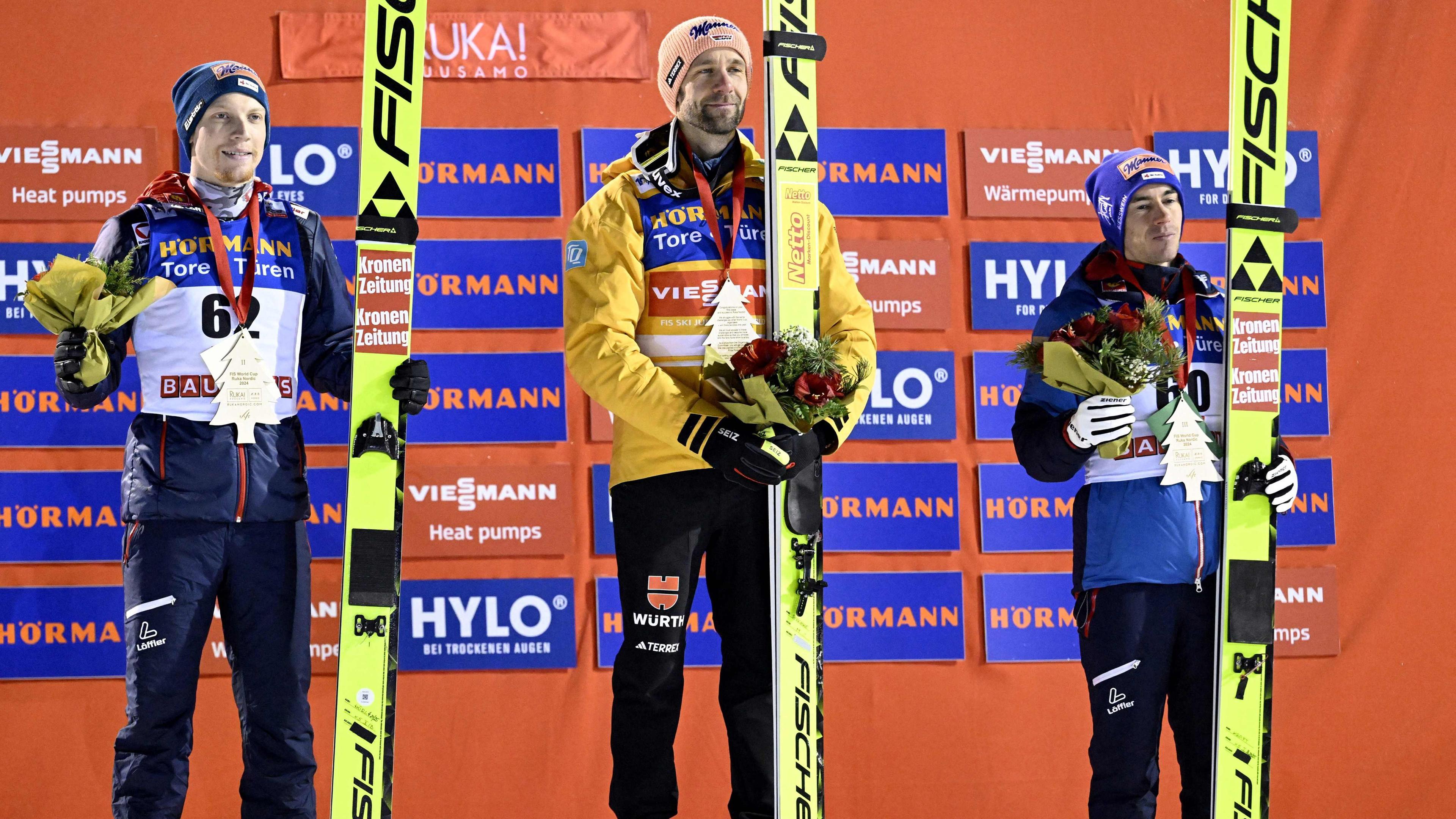 Der zweitplatzierte Österreicher Jan Hoerl, der Sieger Pius Paschke aus Deutschland und der drittplatzierte Österreicher Stefan Kraft feiern auf dem Podium nach dem Herren-Skisprung-Großschanze-HS142-Event des FIS World Cup Ruka Nordic in Kuusamo, Finnland