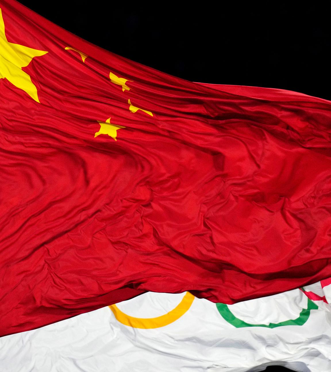 Chinas Flagge vor der Olympischen Flagge