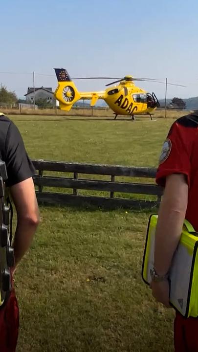 Notarzt auf dem Weg zum Rettungs-Hubschrauber, im Hintergrund zu sehen. 