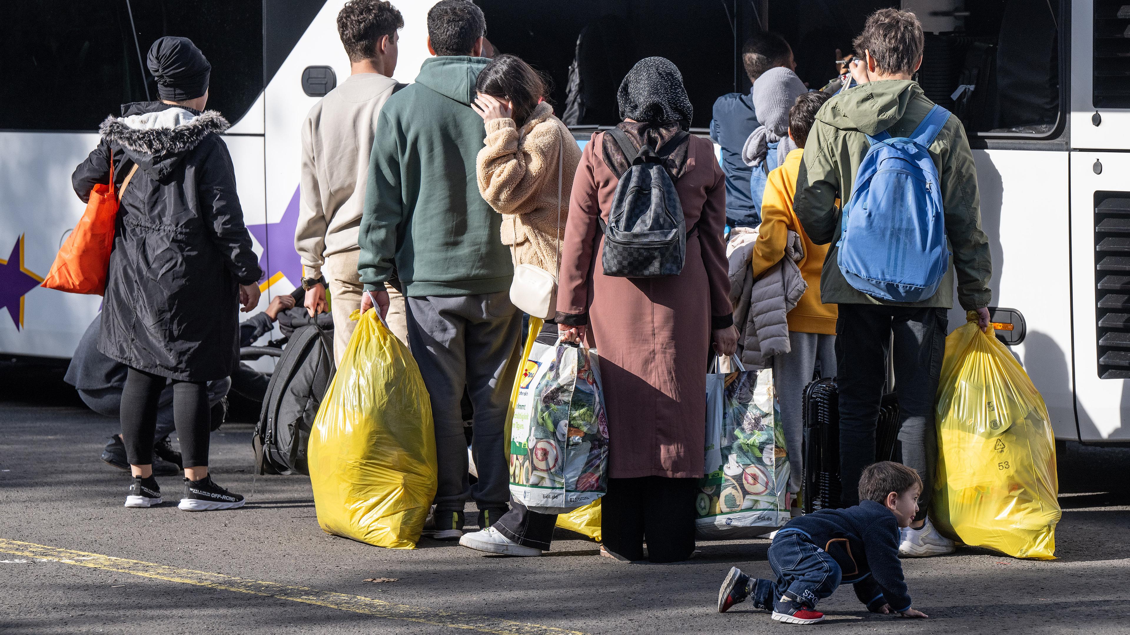 Flüchtlinge laden ihr Gepäck in Bus, aufgenommen am 11.10.2023 in Gießen