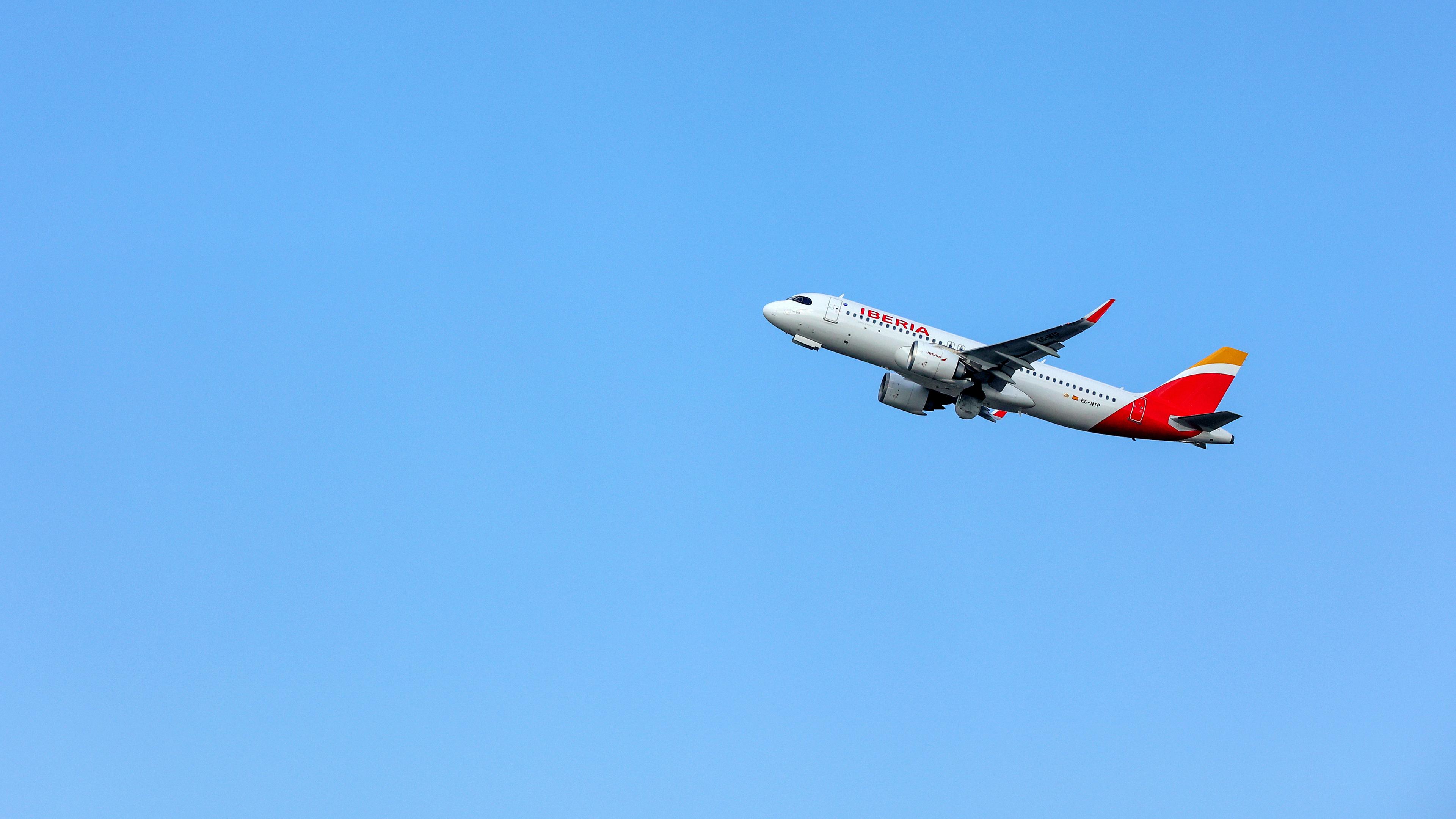 Eine Maschine der Fluggesellschaft Iberia nach Start vor blauem Himmel.