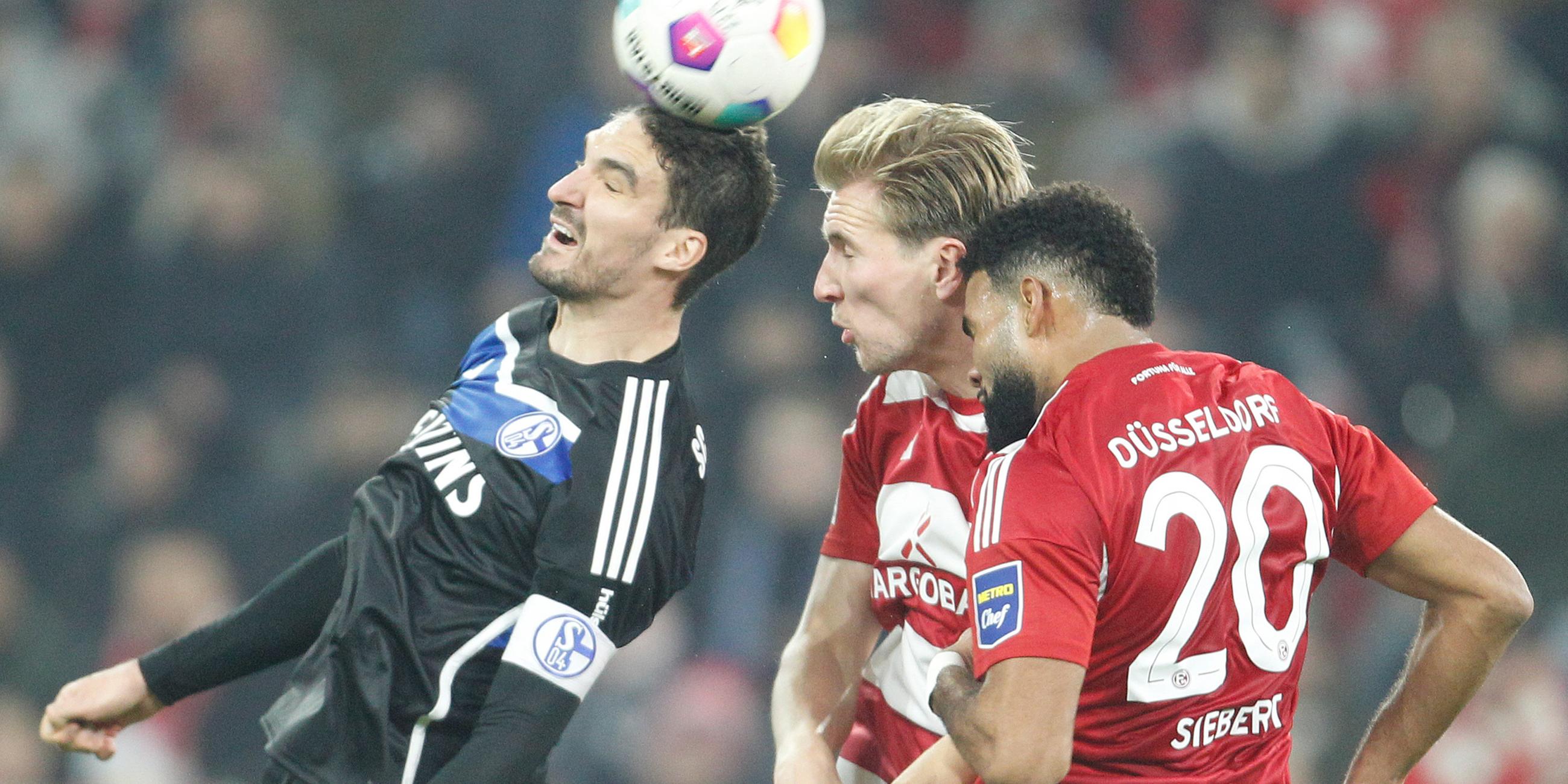 Die Düsseldorfer Vincent Vermeij (M) und Jamil Siebert (r) und der Schalker Marcin Kaminski (l) kämpfen um den Ball. 