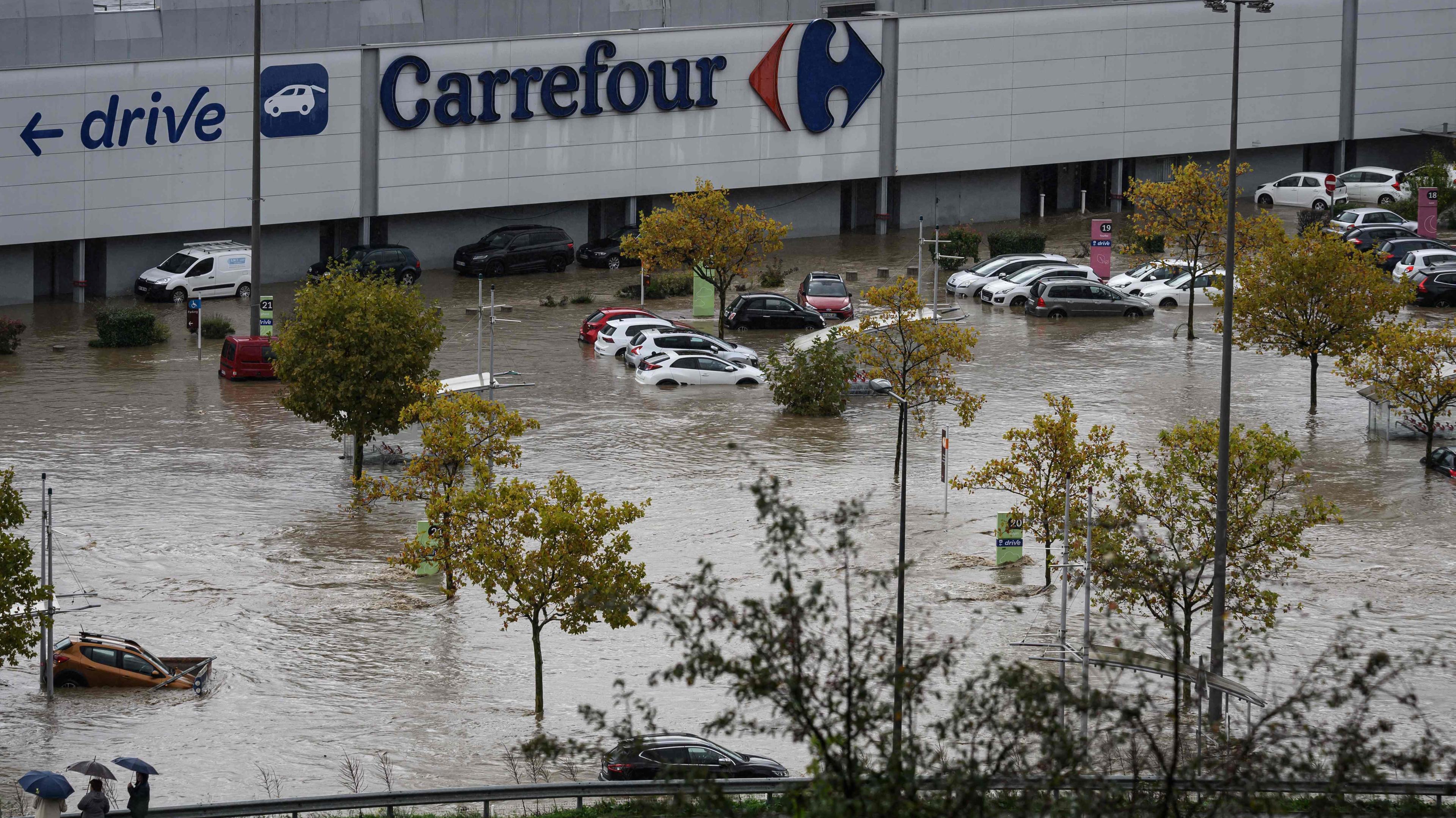 Autos stehen auf einem überschwemmten Parkplatz in Frankreich.