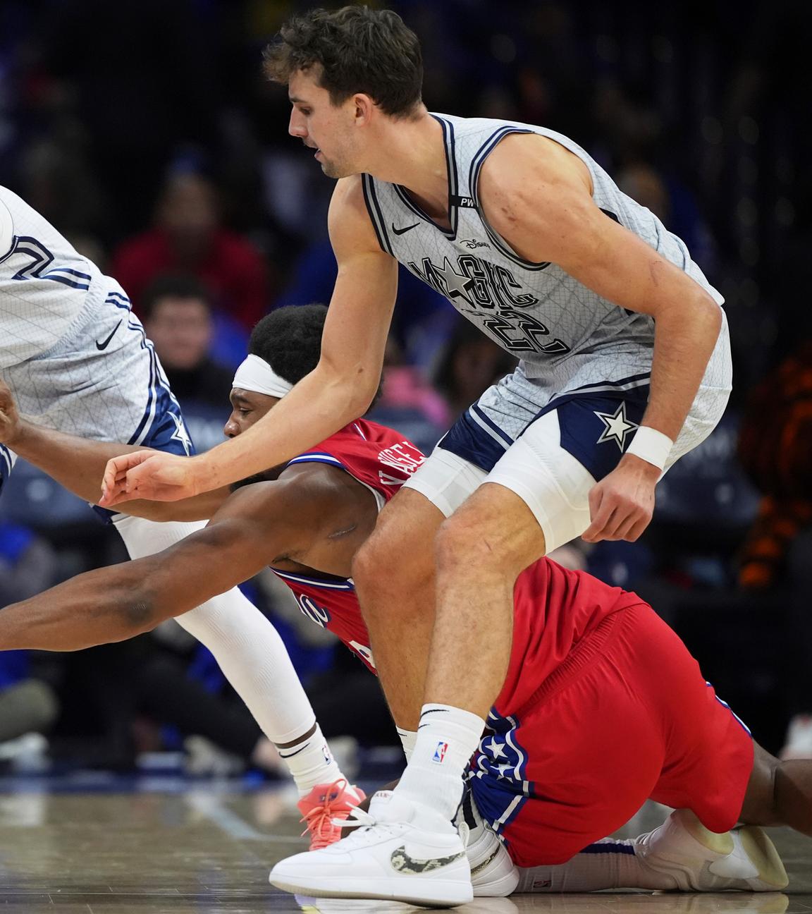 Kentavious Caldwell-Pope (links) und Franz Wagner (rechts) von den Orlando Magic kämpfen mit Guerschon Yabusele (Mitte) um den Ball.