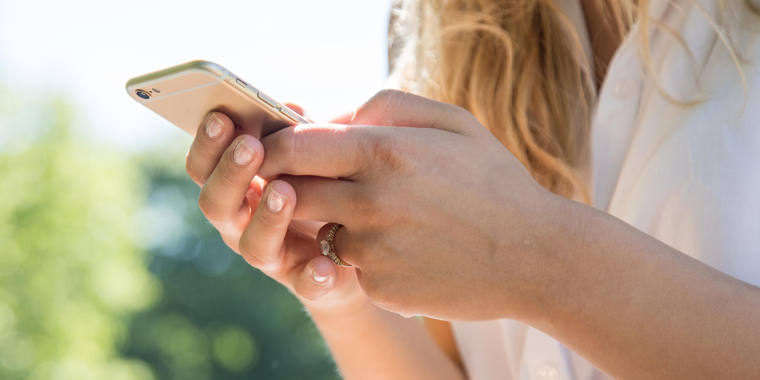 Es ist eine Frau am Smartphone zu sehen