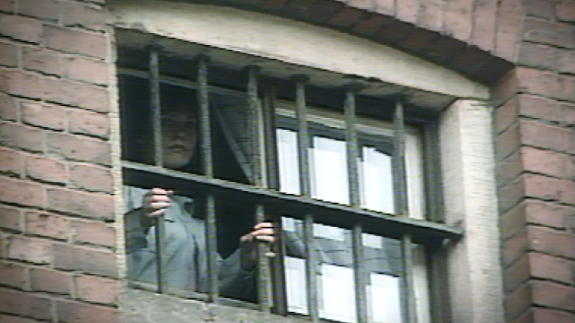 Frau im Gefängnis hinter Gittern