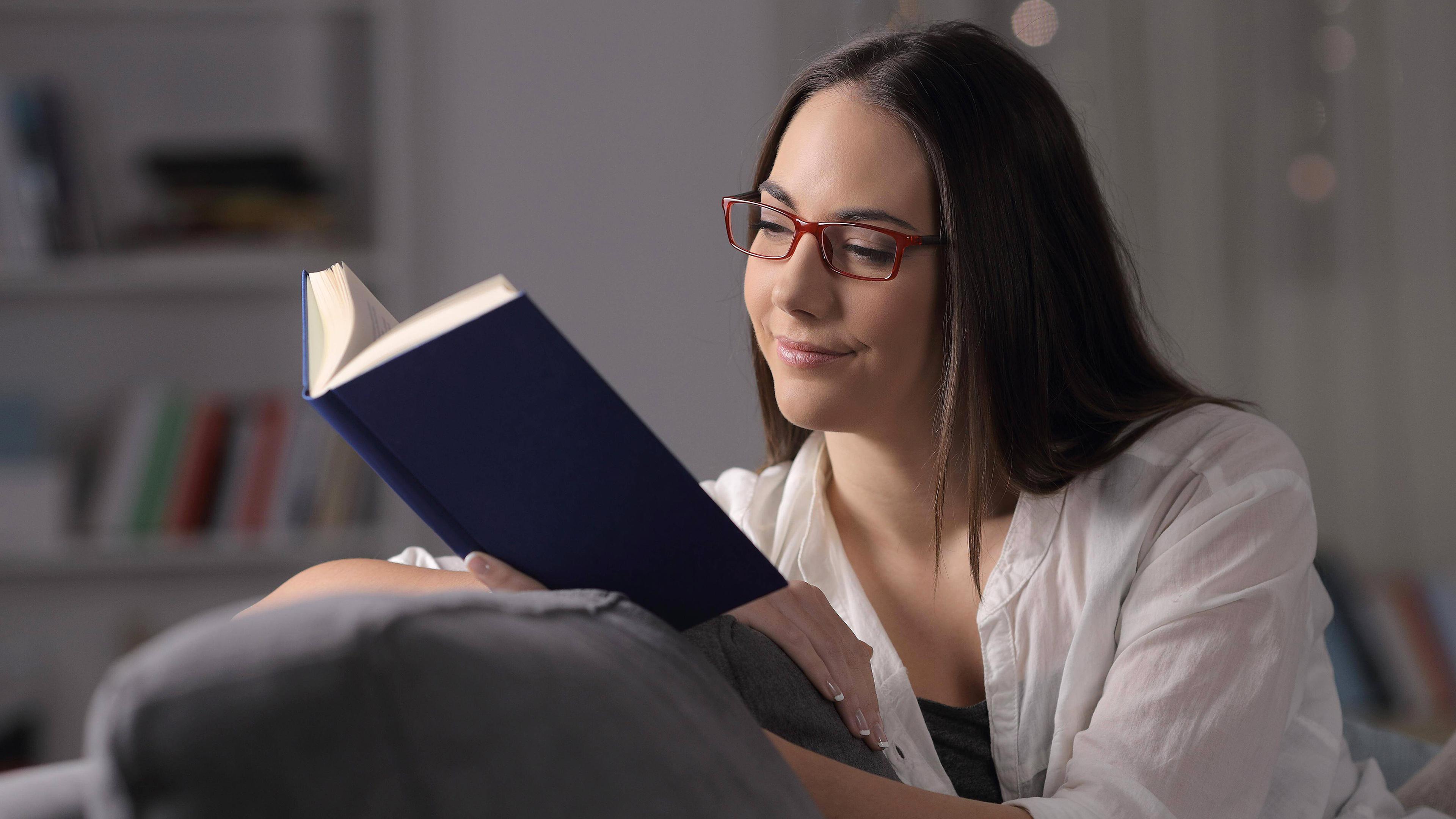 Eine Frau liest ein Buch auf der Couch