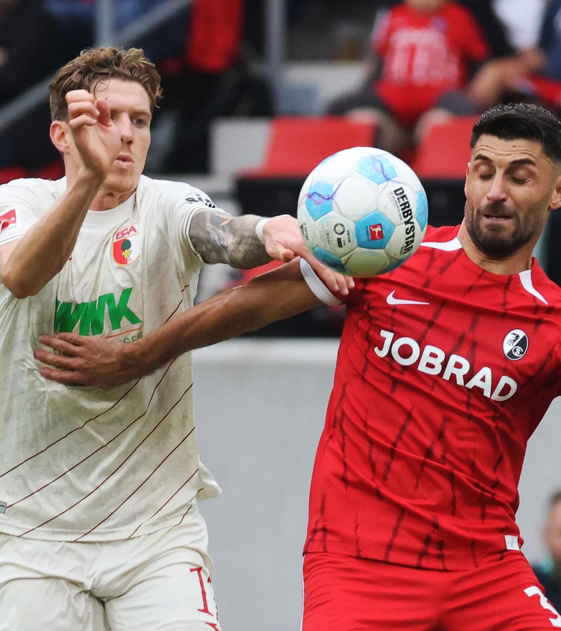 Augsburgs Kristijan Jakic (l) und Freiburgs Vincenzo Grifo (r) im Zweikampf.