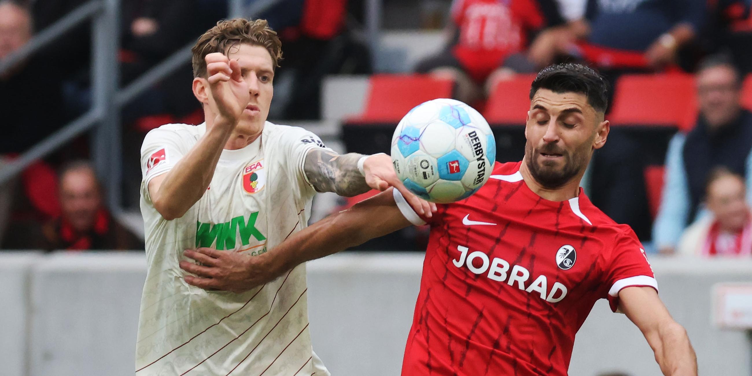 Augsburgs Kristijan Jakic (l) und Freiburgs Vincenzo Grifo (r) im Zweikampf.