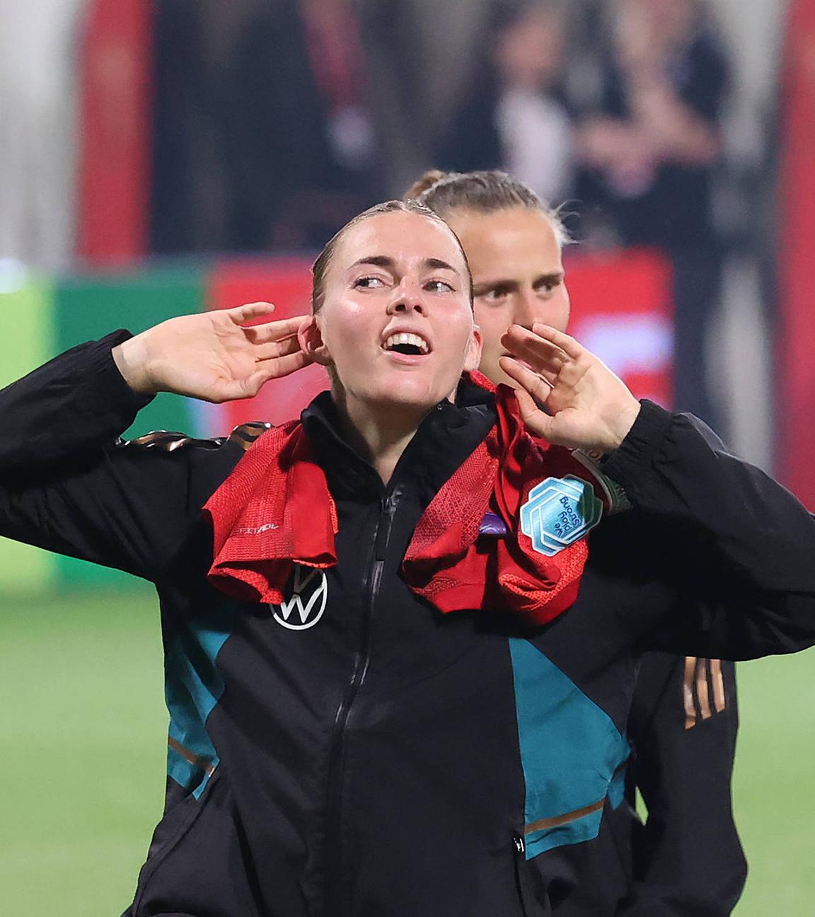 Laura Freigang fordert nach dem 4:1-Sieg der DFB-Frauen in Rostock gegen Polen die Fans zu singen auf und hält sich beide Hände an die Ohrmuscheln.