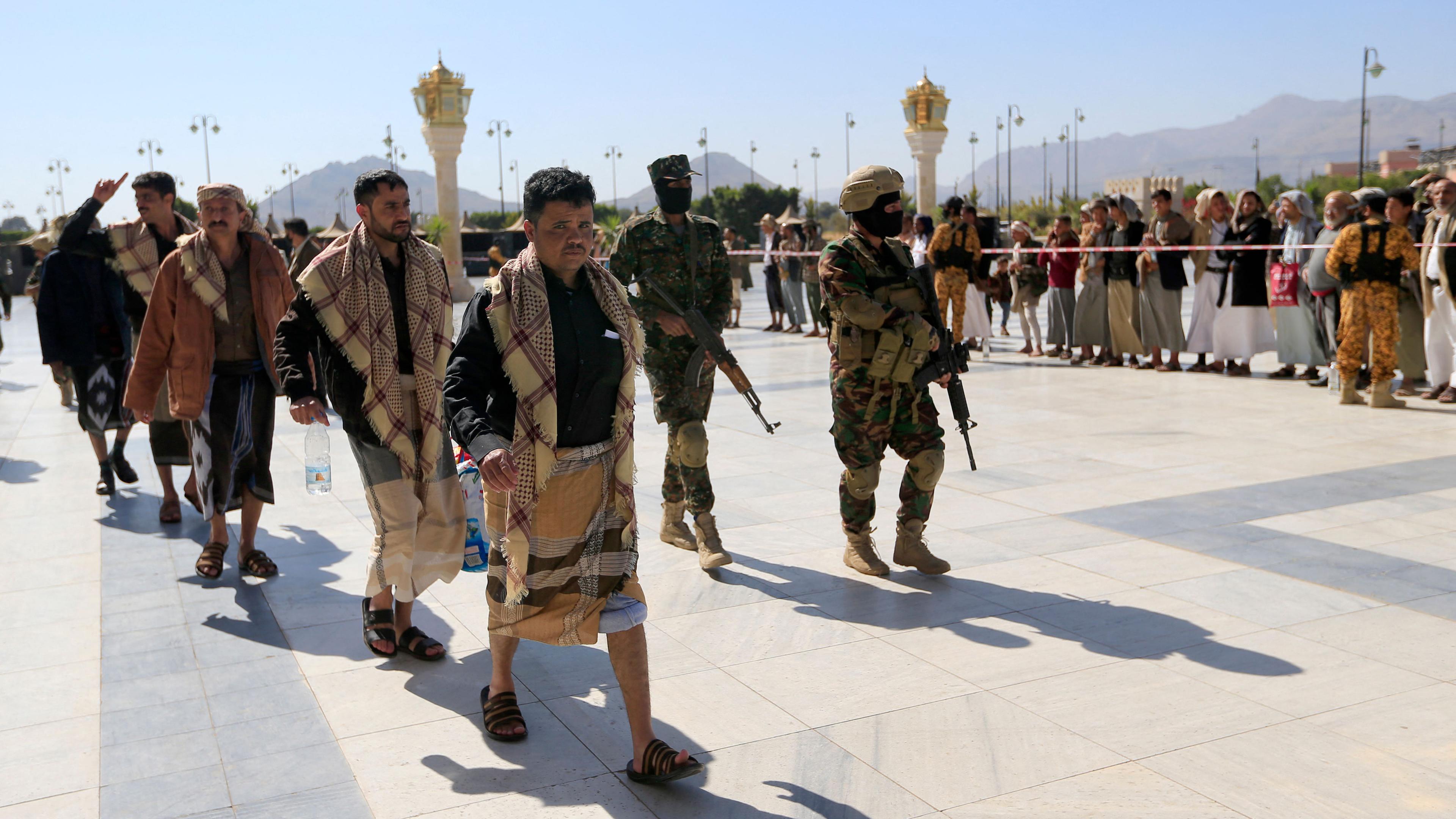 Huthi-Kämpfer begleiten am 25. Januar 2025 in Sanaa frisch freigelassene jemenitische Gefangene auf ihrem Weg zu ihren Angehörigen.