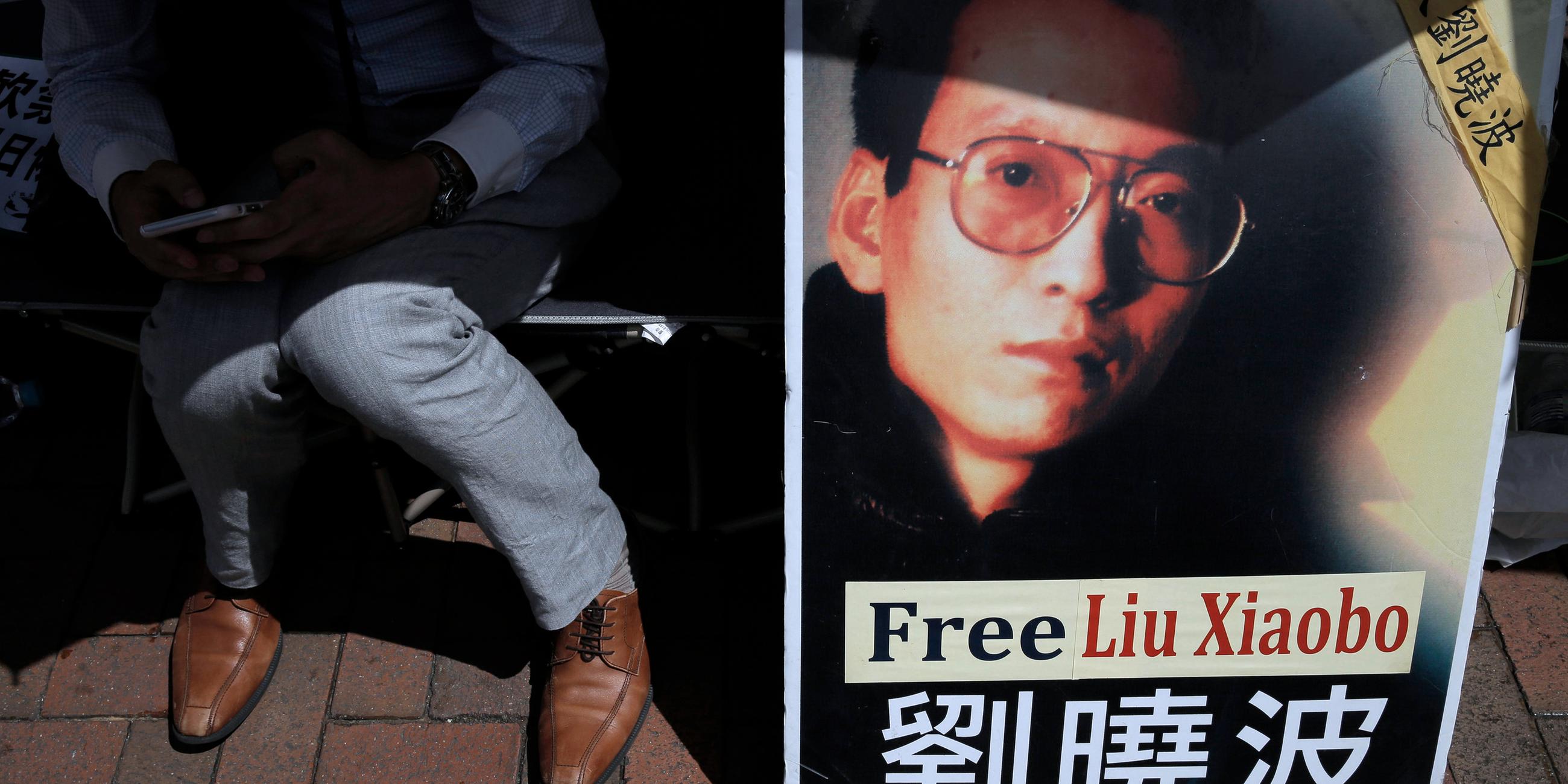 Ein Demonstrant zeigt während einer Demonstration vor dem chinesischen Verbindungsbüro in Hongkong ein Porträt des inhaftierten chinesischen Friedensnobelpreisträgers Liu Xiaobo