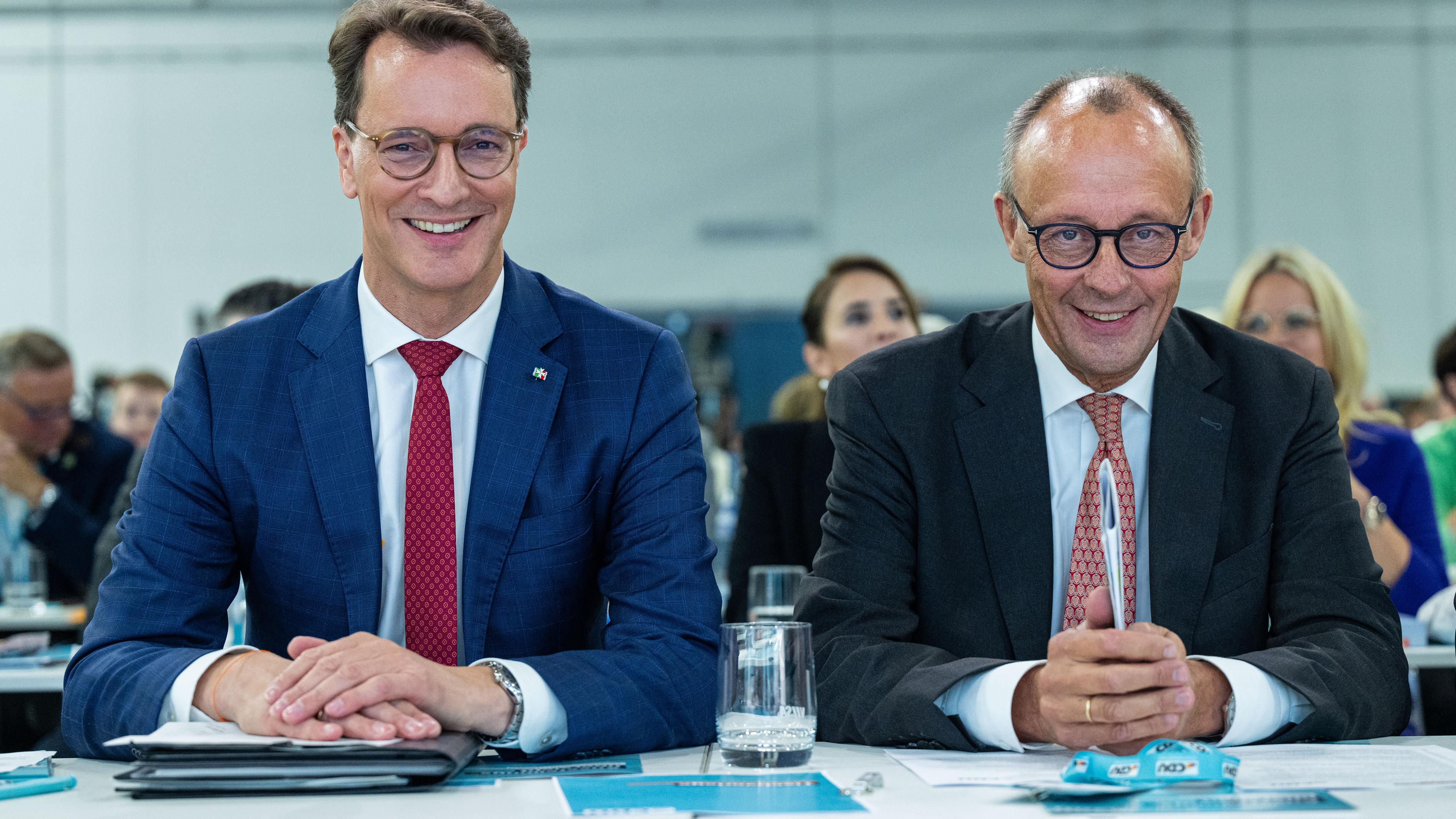 Nordrhein-Westfalen, Münster: Friedrich Merz (r), CDU-Bundesvorsitzender und Unionsfraktionsvorsitzender und Hendrik Wüst (CDU), Ministerpräsident von Nordrhein-Westfalen, sitzen zusammen auf dem 46. Landesparteitag der CDU Nordrhein-Westfalen.