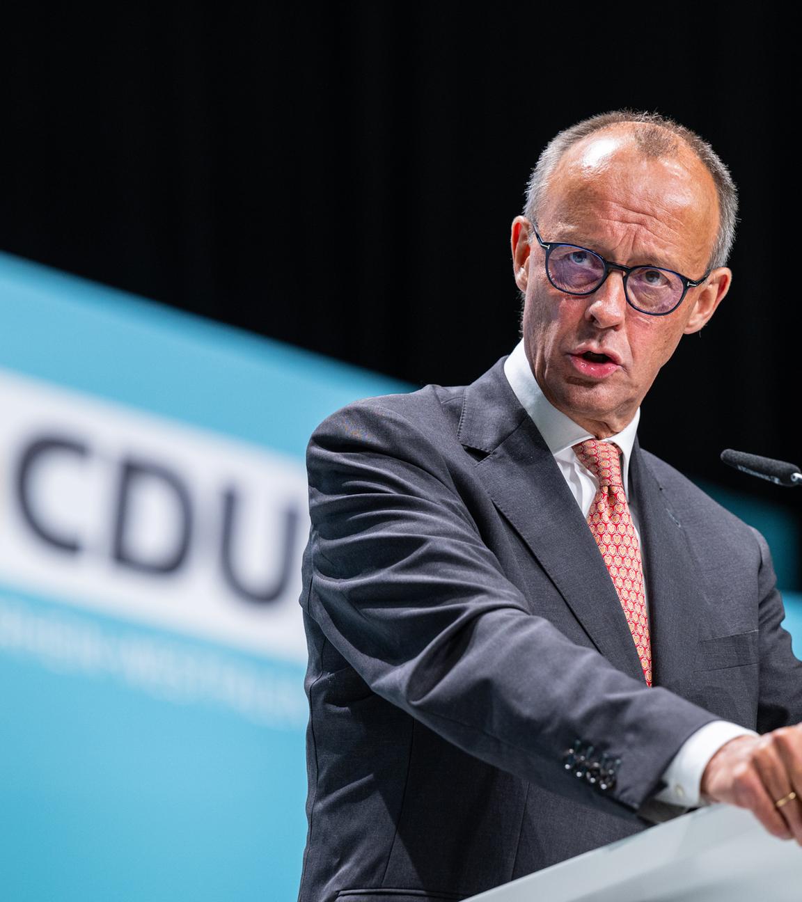 CDU-Chef Friedrich Merz am Rednerpult vor einem CDU-Logo im Hintergrund.