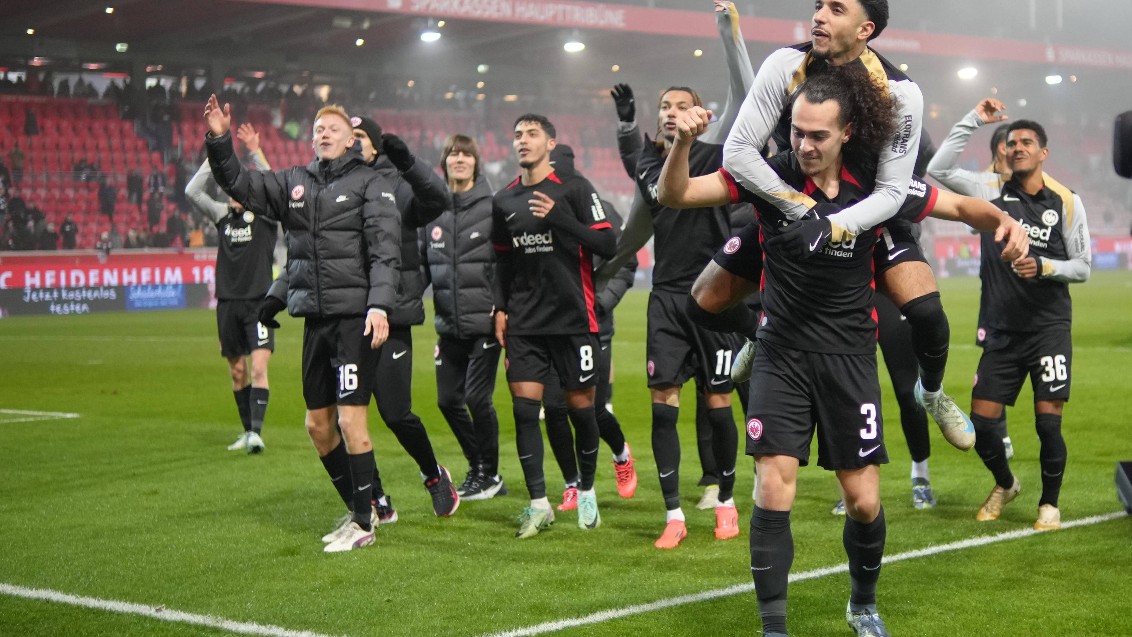 Fußball, Bundesliga, 1. FC Heidenheim - Eintracht Frankfurt: Willian Pacho (3 Eintracht Frankfurt) und Omar Marmoush (7 Eintracht Frankfurt) feiern nach dem Sieg mit den Fans beim Bundesligaspiel 1. FC Heidenheim - Eintracht Frankfurt