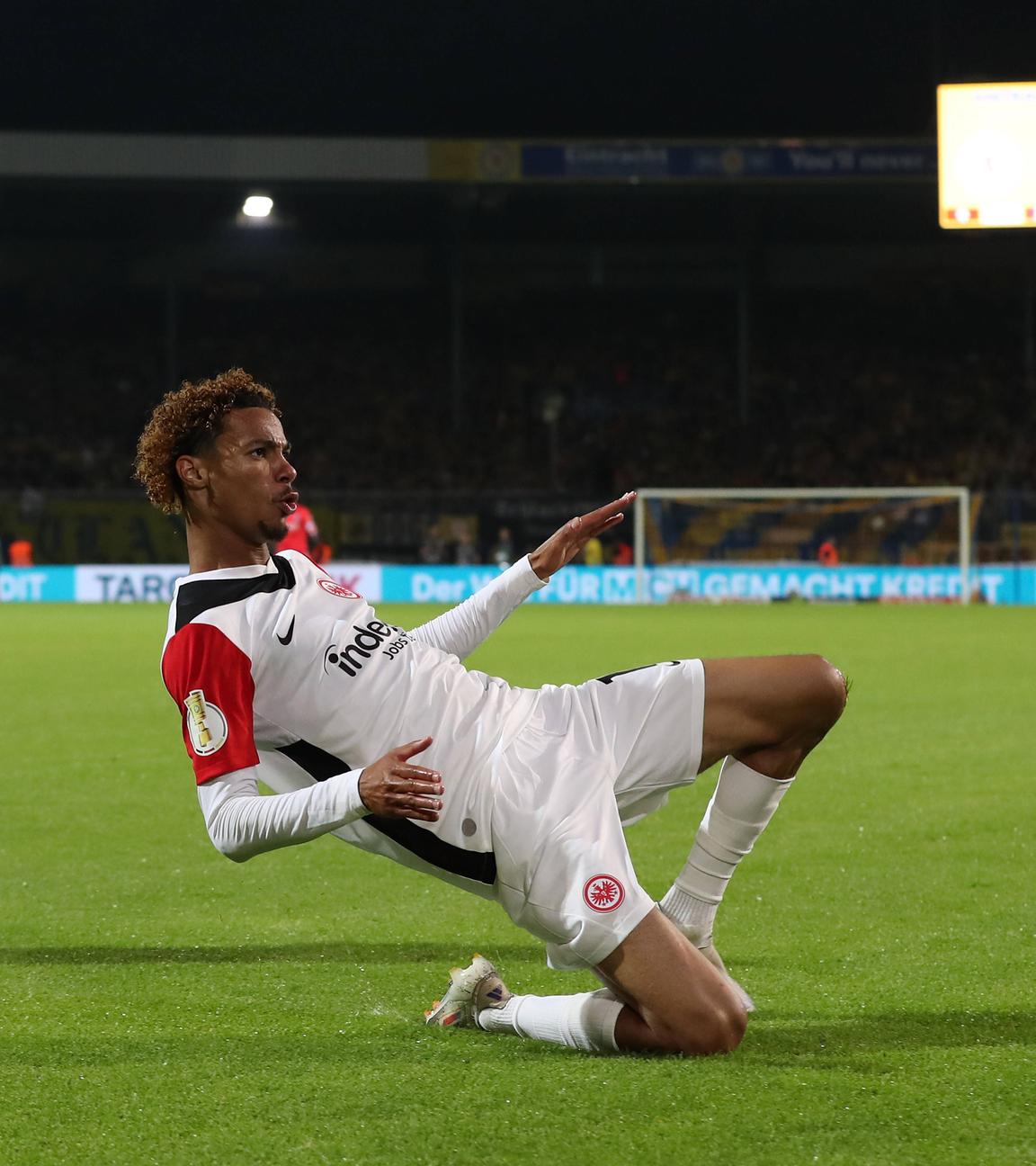 Frankfurts Hugo Ekitike jubelt im Rutschen im Spiel gegen Eintracht Braunschweig über sein Tor.