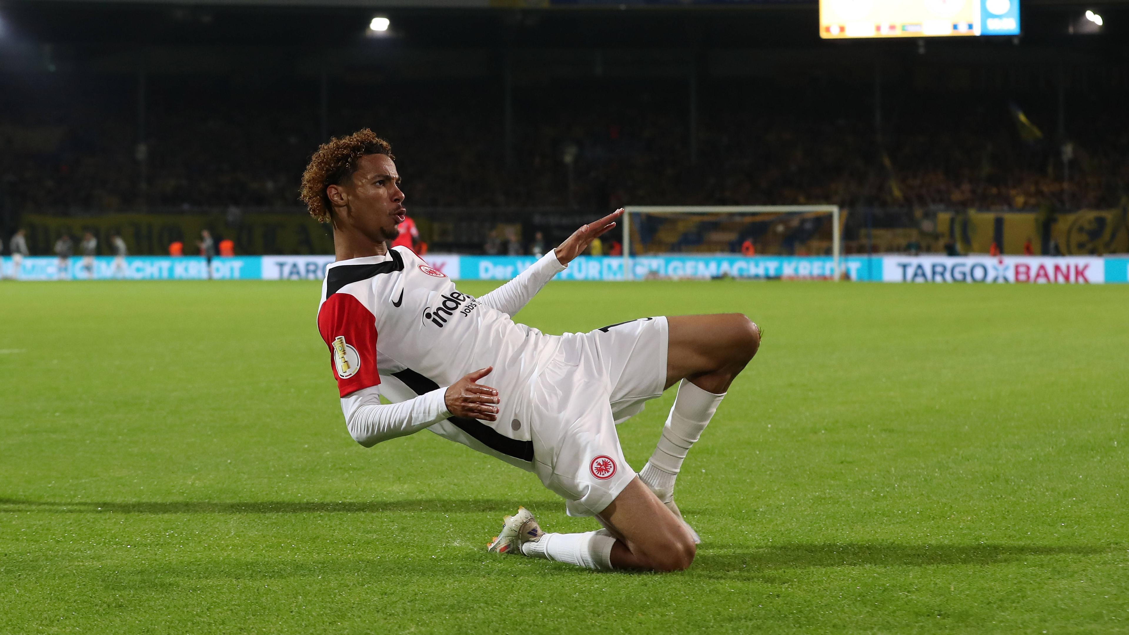 Frankfurts Hugo Ekitike jubelt im Rutschen im Spiel gegen Eintracht Braunschweig über sein Tor.