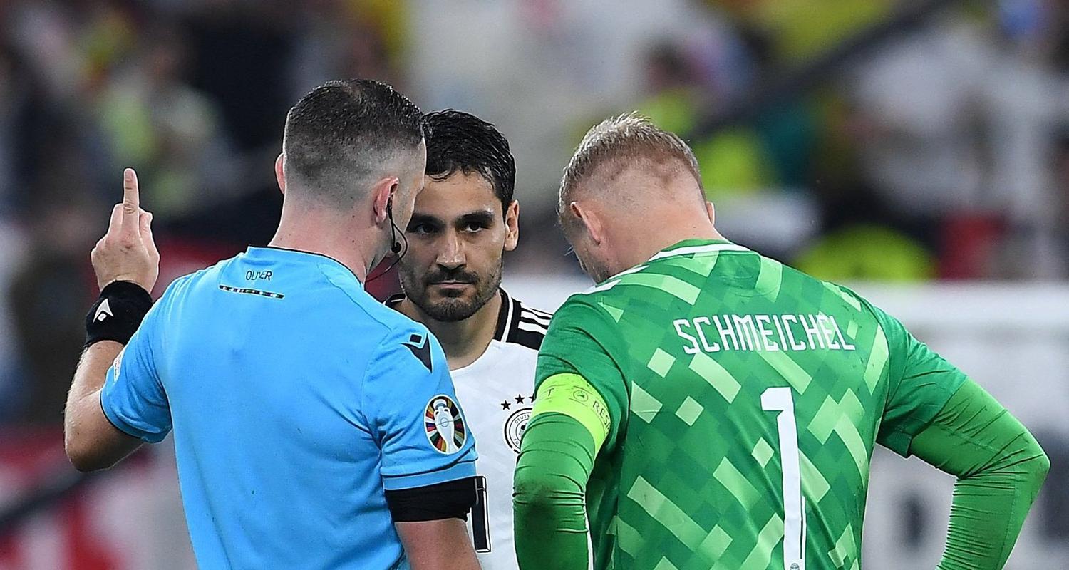 Schiedsrichter Michael Oliver spricht mit den Kapitänen Ilkay Gündogan und Kasper Schmeiche