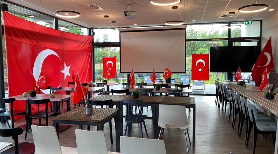 Der Clubraum des Fußball-Vereins Anadolu Türkspor. In ihm stehen mehrere Tische und mehrere Flaggen der Türkei hängen an den Wänden.