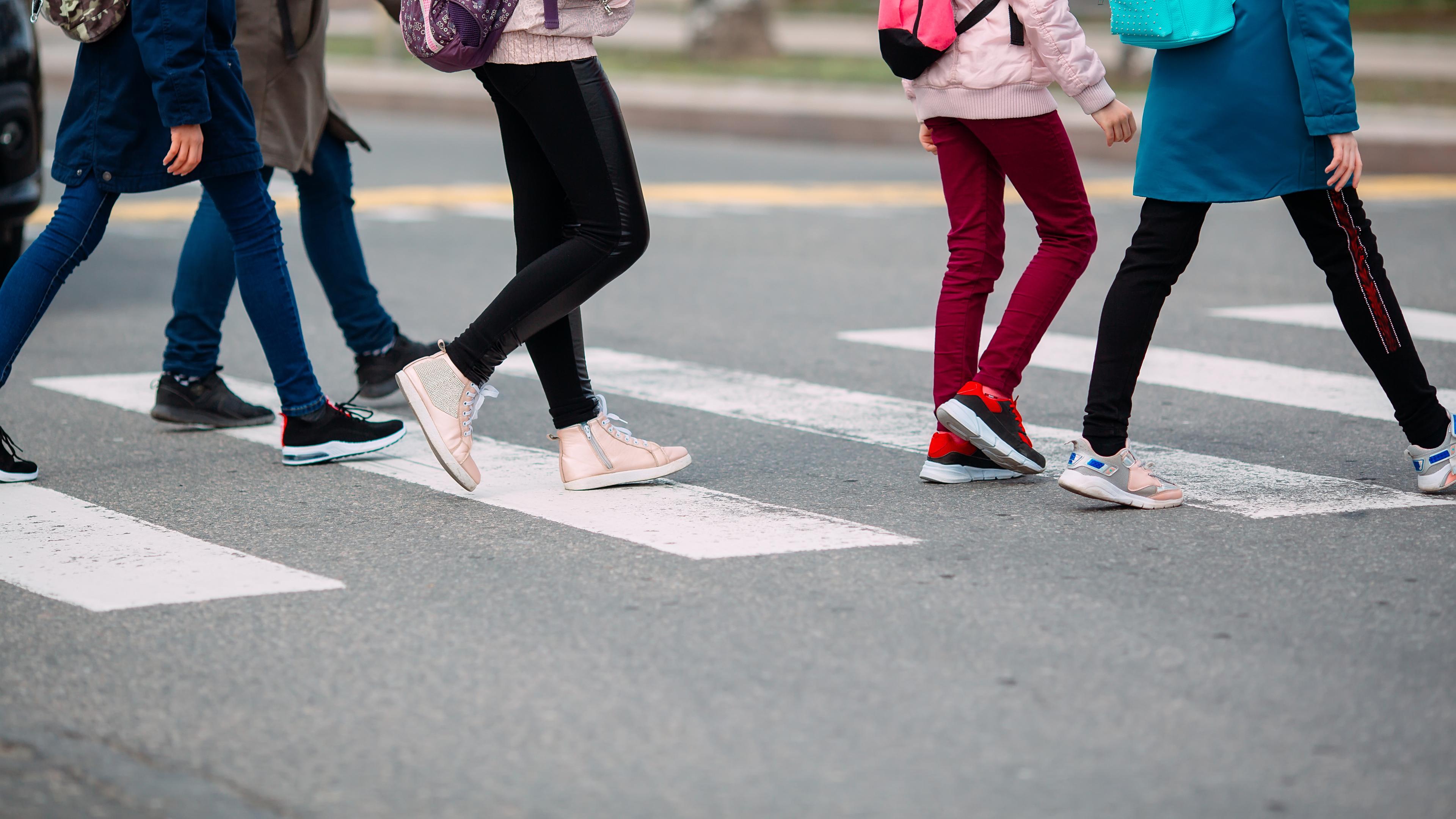 Schüler überqueren einen Zebrastreifen.