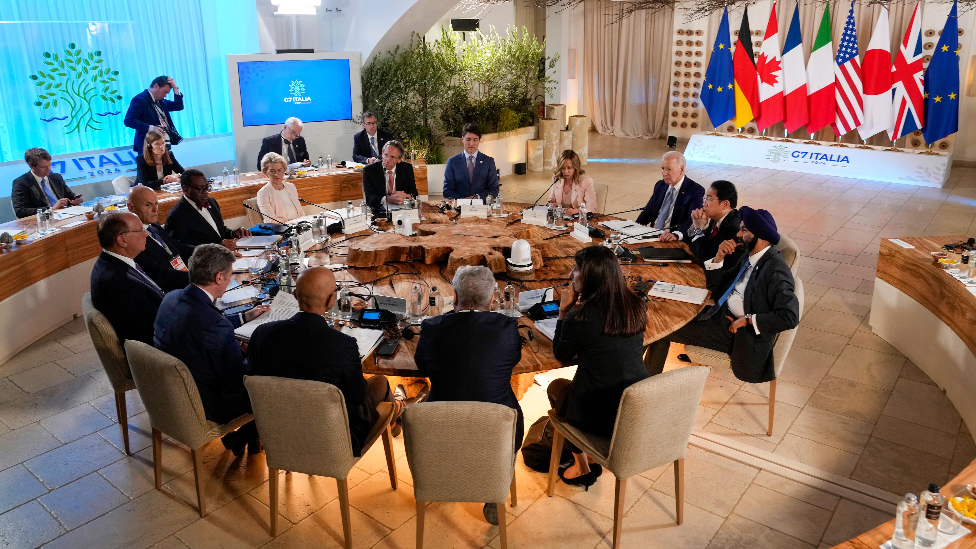 Die Staats- und Regierungschefs der G7 beim Gipfel in Italien an einem Tisch mit Gastgeberin Meloni.
